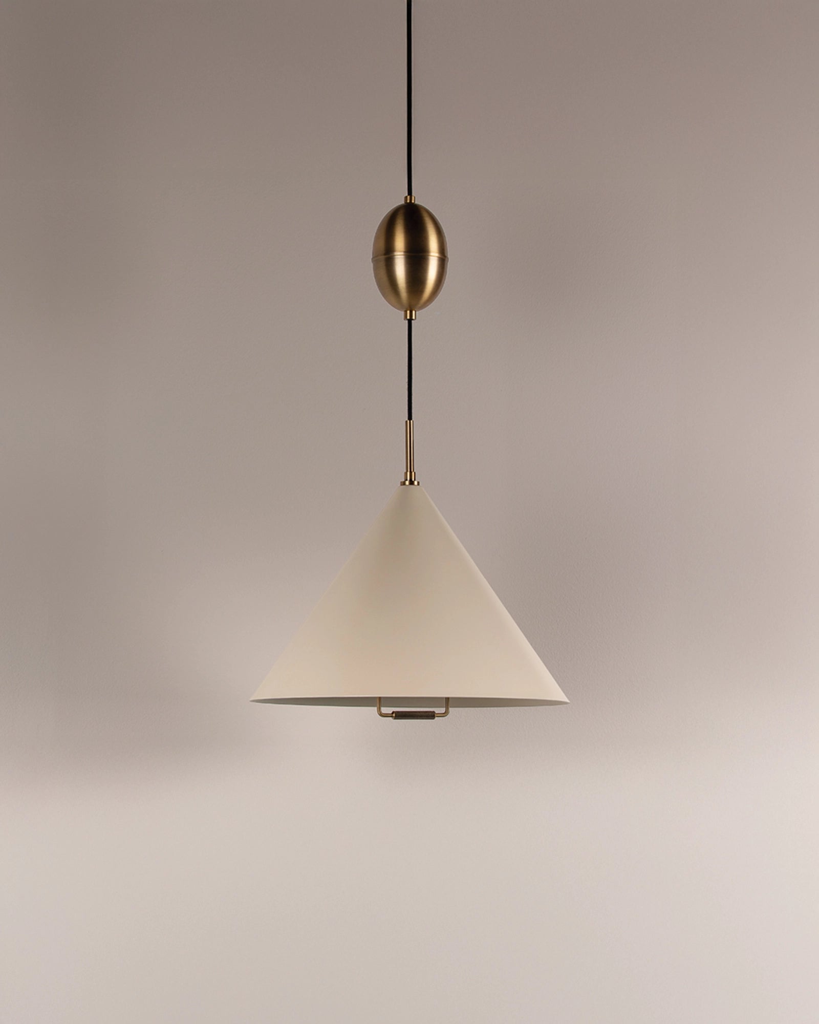 Pendant light with white shade and gold fixture on a neutral background