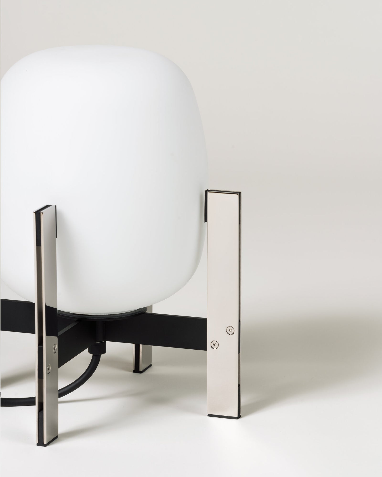 Contemporary table lamp called the Cestita Metallic Table Lamp in chrome finish by Santa & Cole featured in a living room.