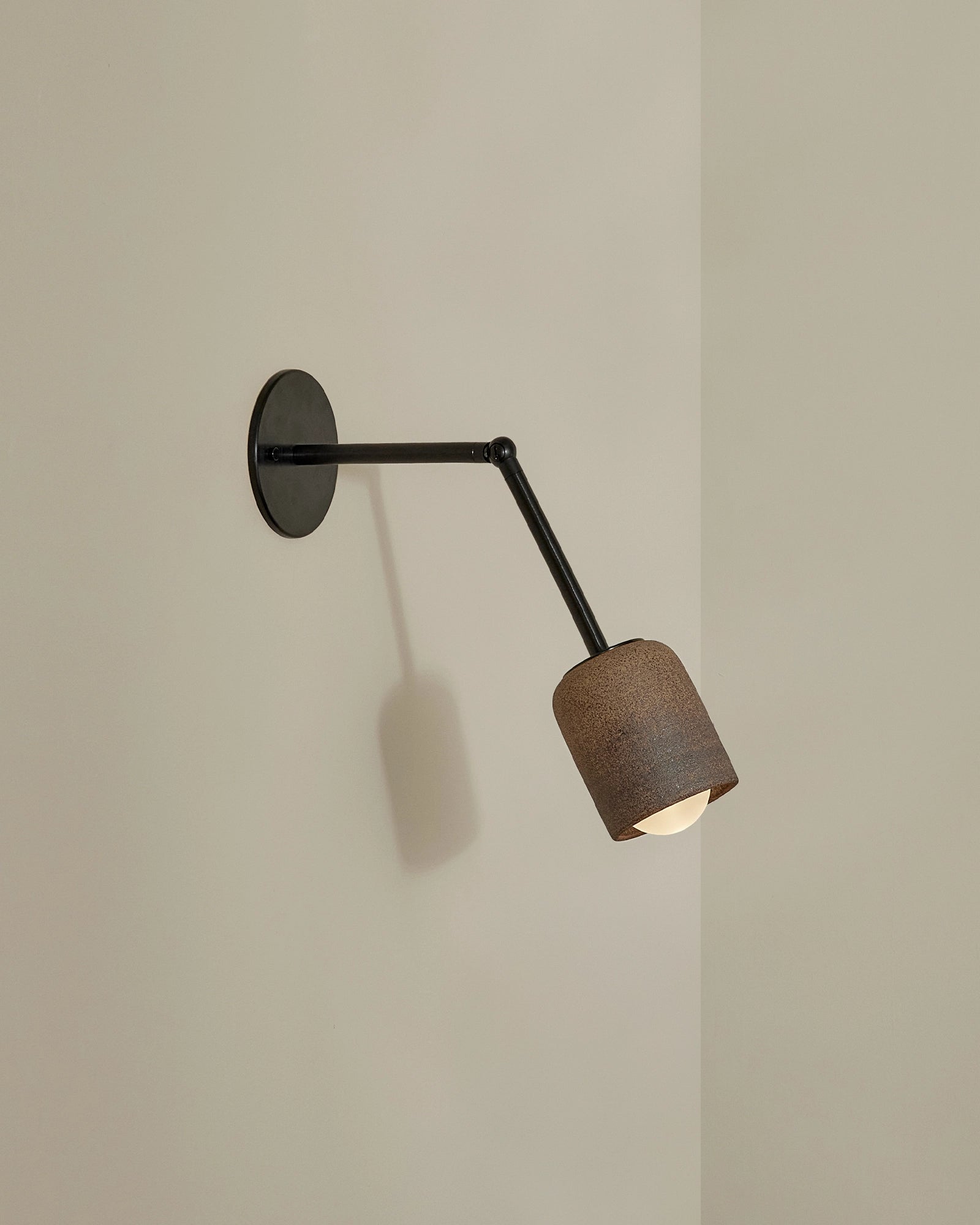 Terra 1 Long Arm Wall Light in Clay ceramic finish with brushed black metal finish. -Nook Collections