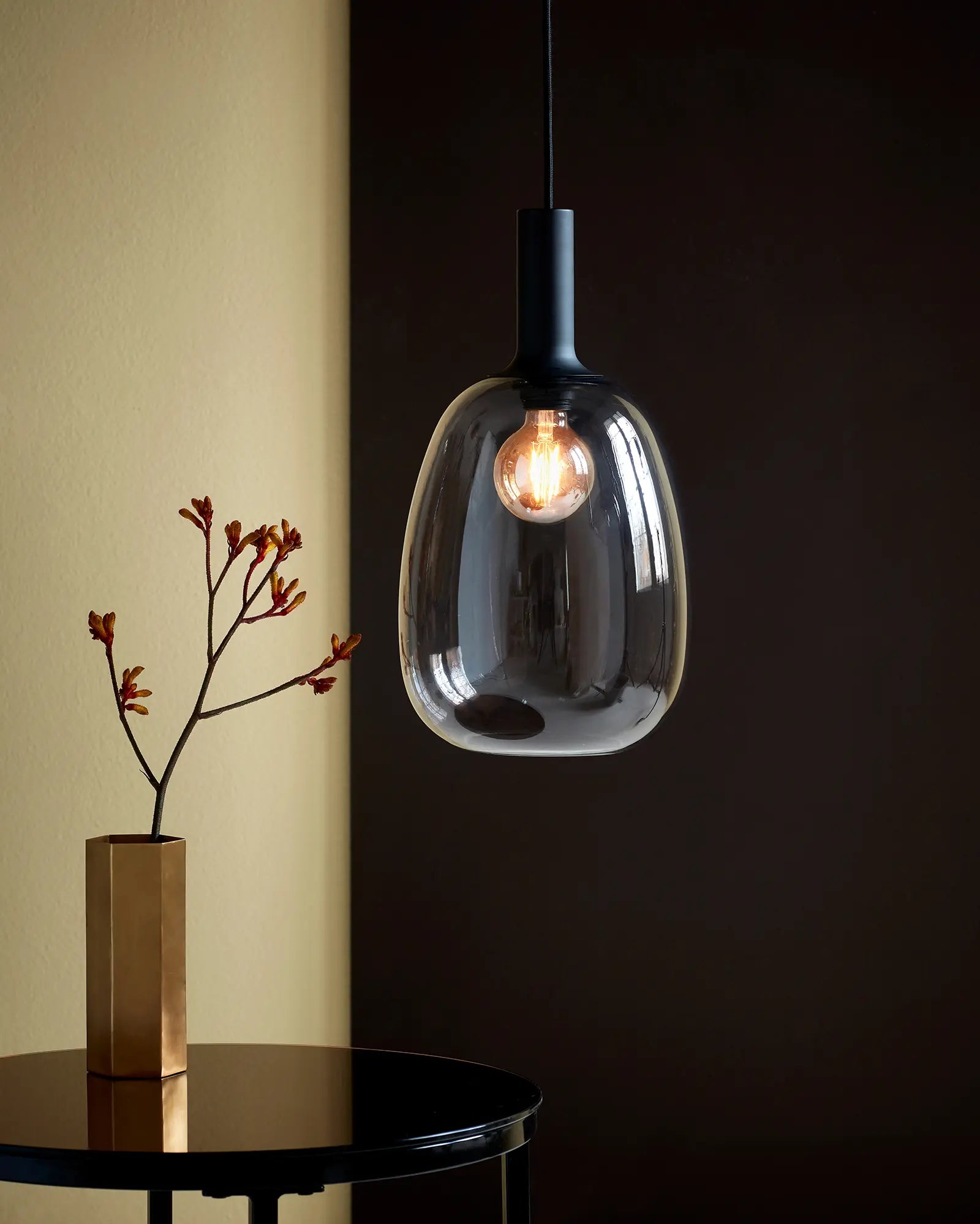 Alton Scandinavian Pendant light in blown glass smoke and black above a coffee table
