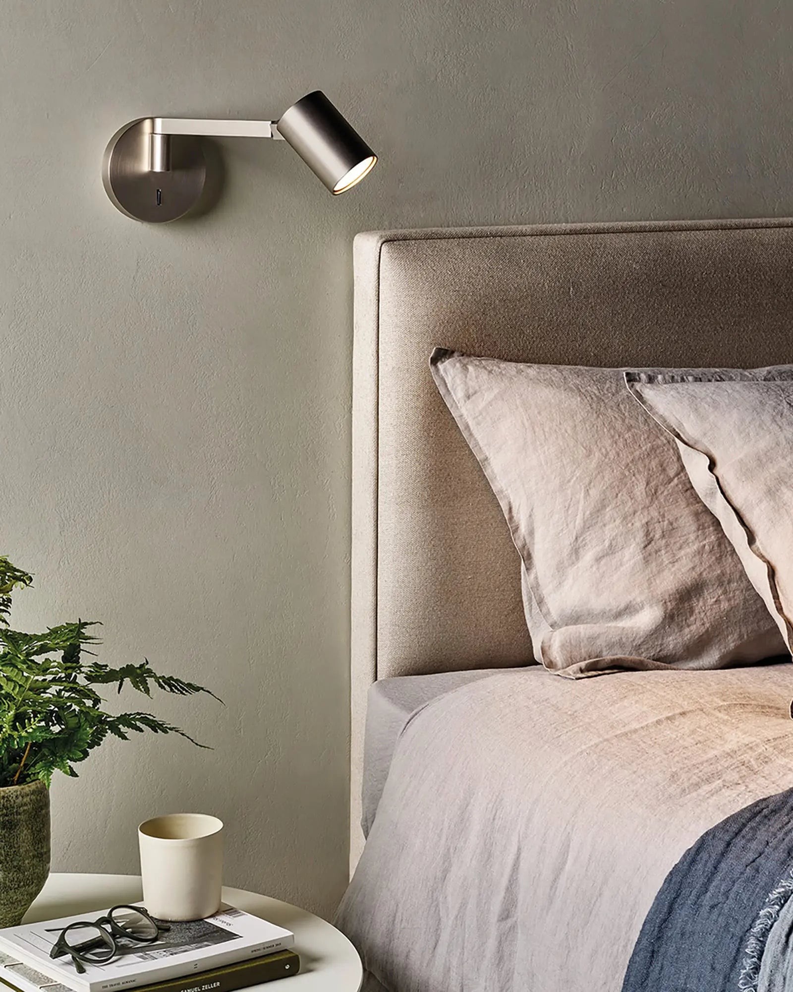 Ascoli swing adjustable wall light in bronze on the bed side