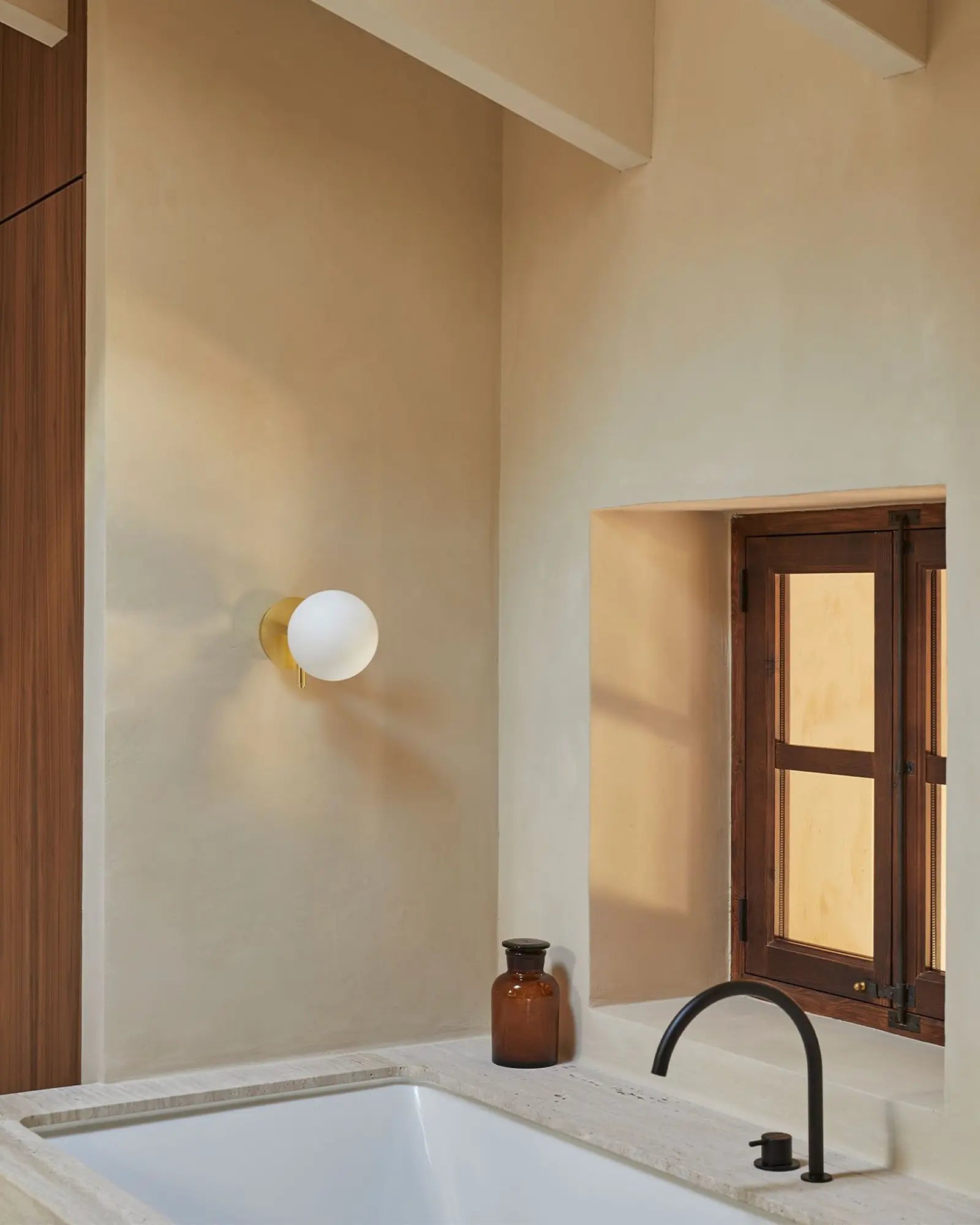 Atom Contemporary orb opal glass shade wall light in a bathroom