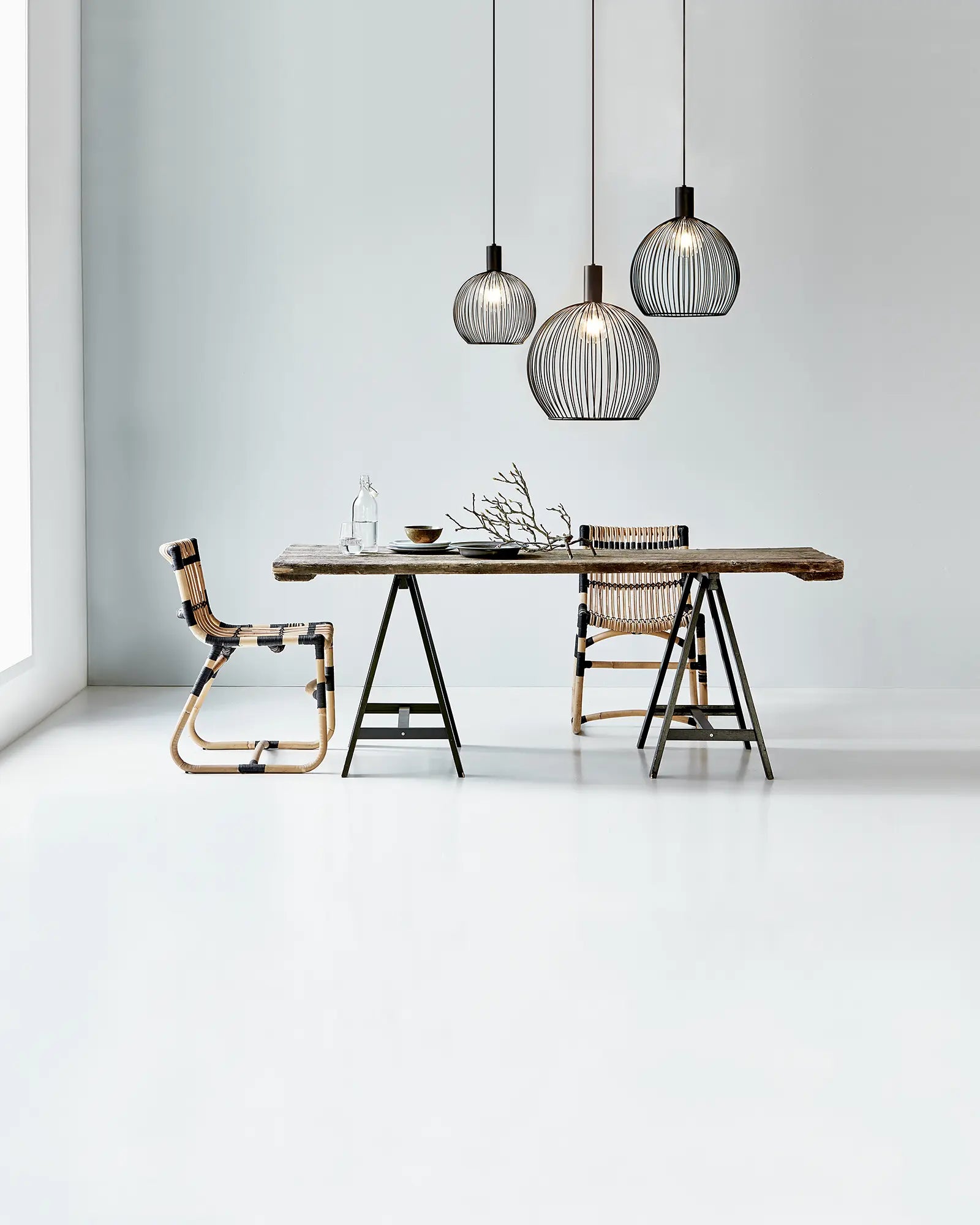 Aver bird cage Scandinavian pendant light cluster over a dining table