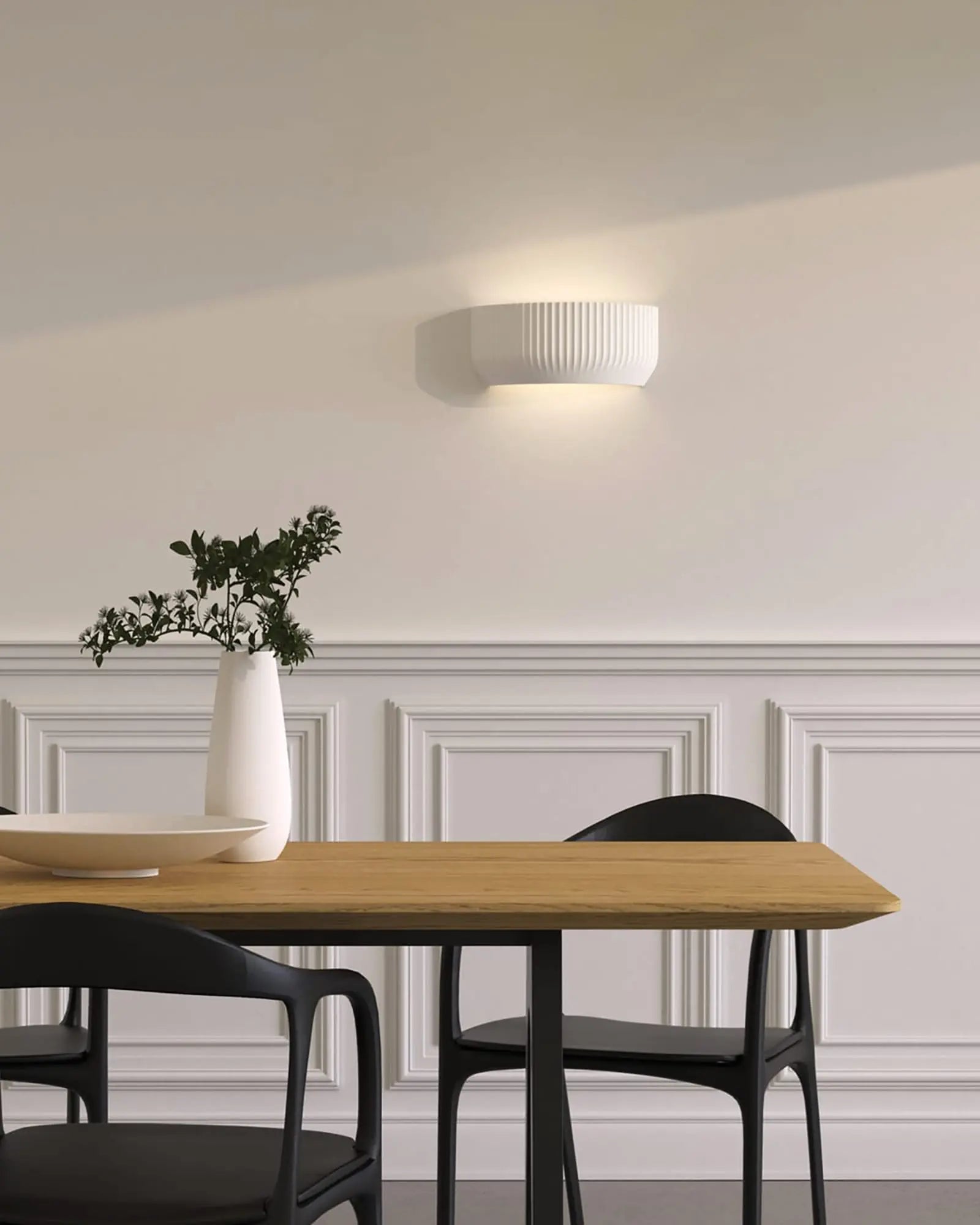 Blend plaster contemporary architectural style wall light behind a dining table