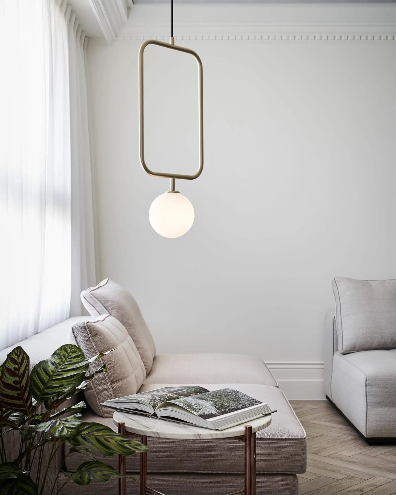 Sircle blown glass pendant light above a coffee table in a living area