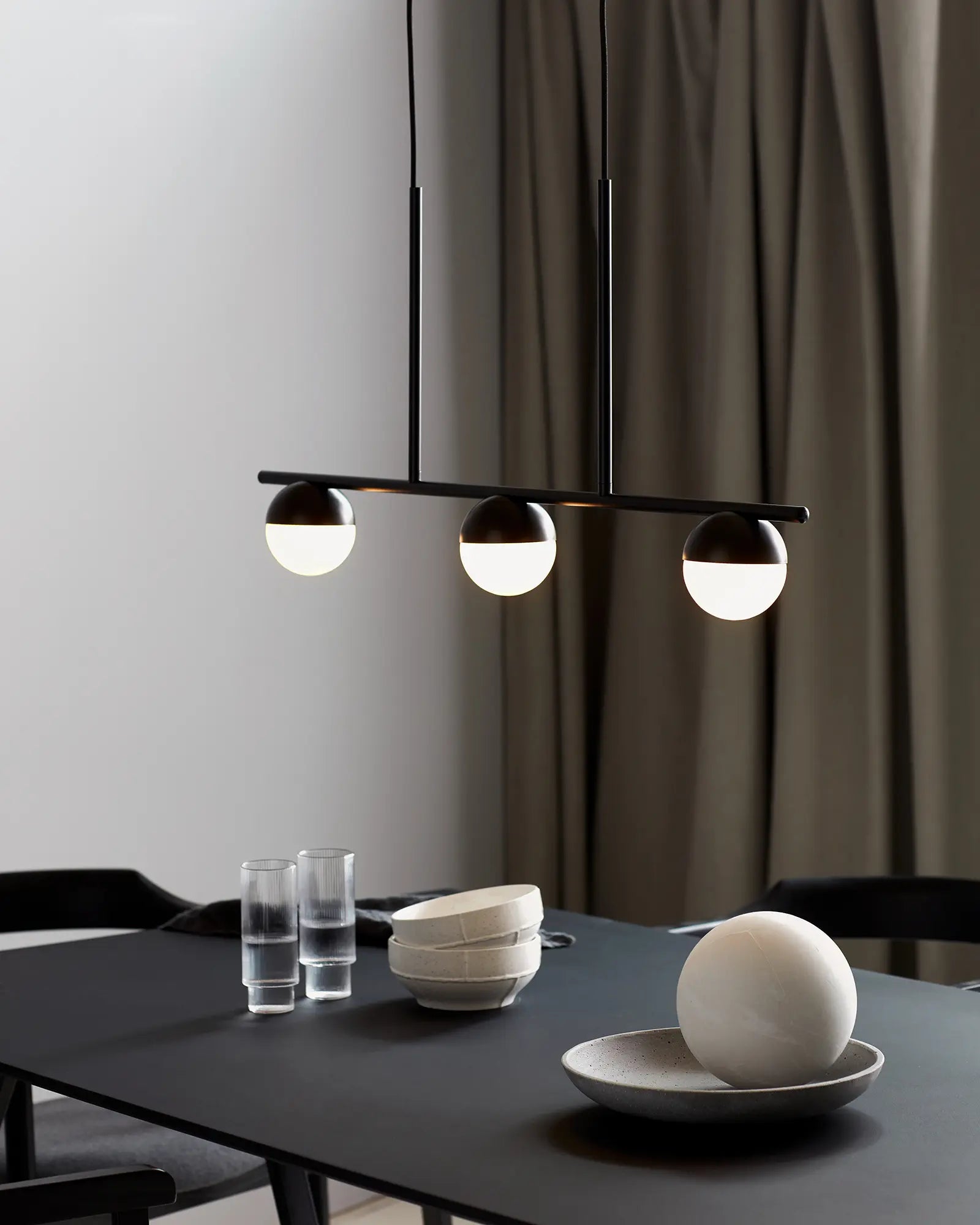 Contina 3 lights linear pendant black above a dining table