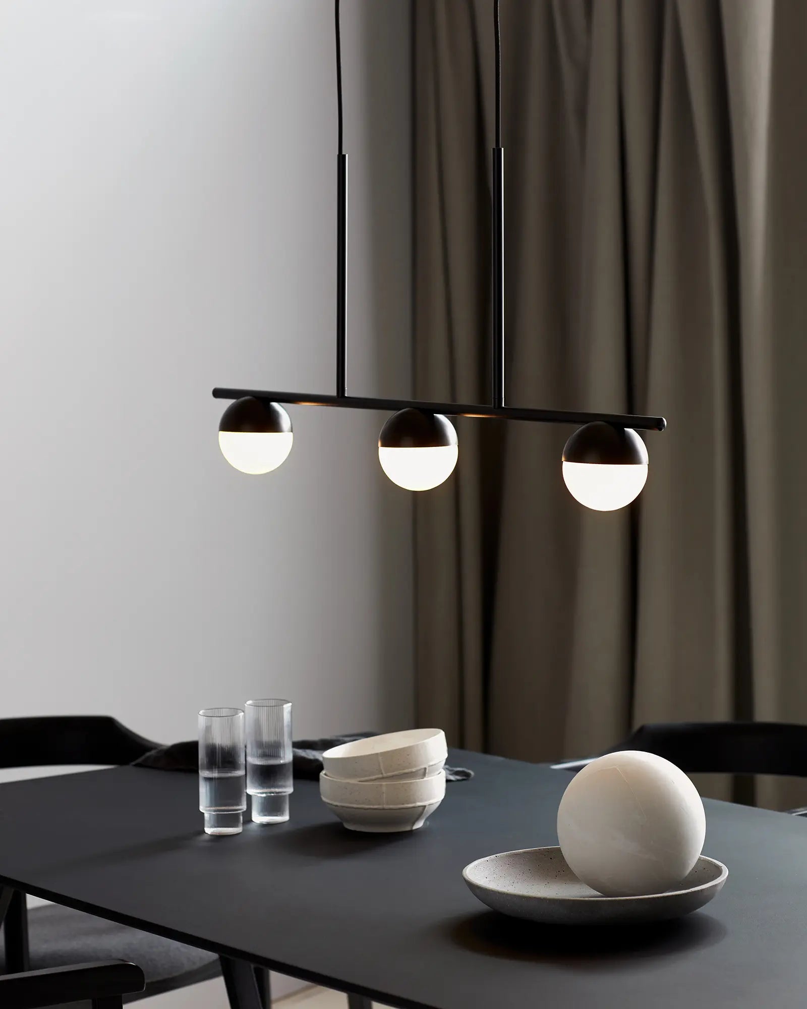 Contina 3 lights linear pendant black above a dining table