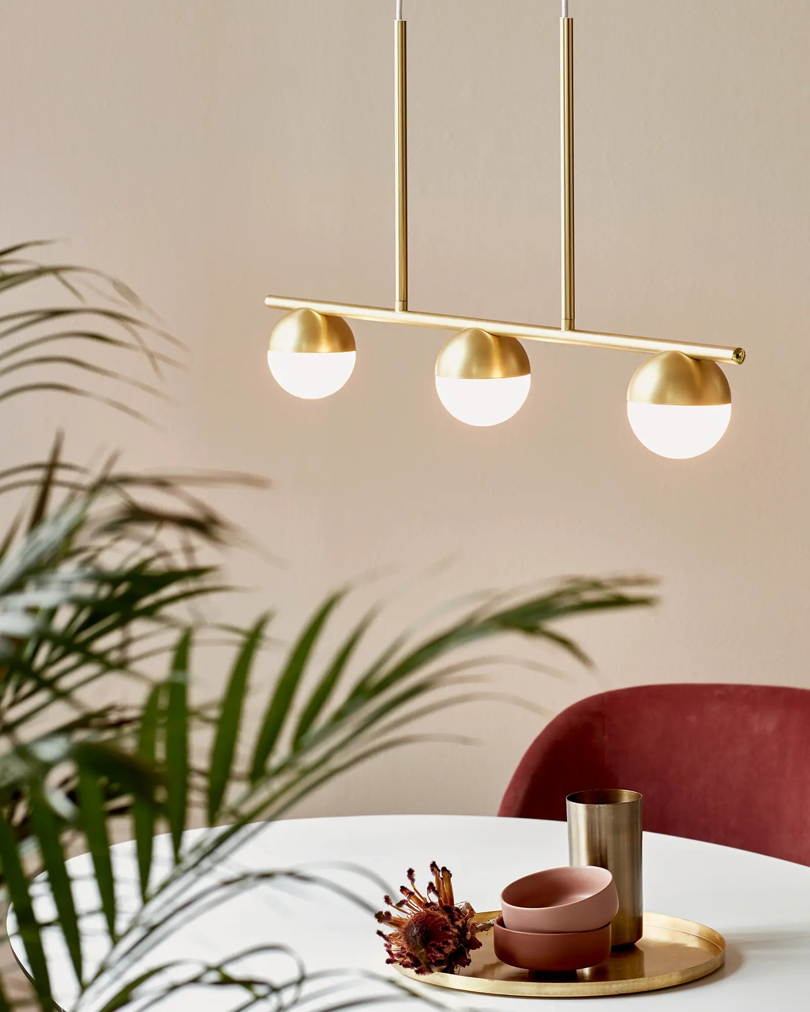Contina 3 lights linear pendant brass above a dining table