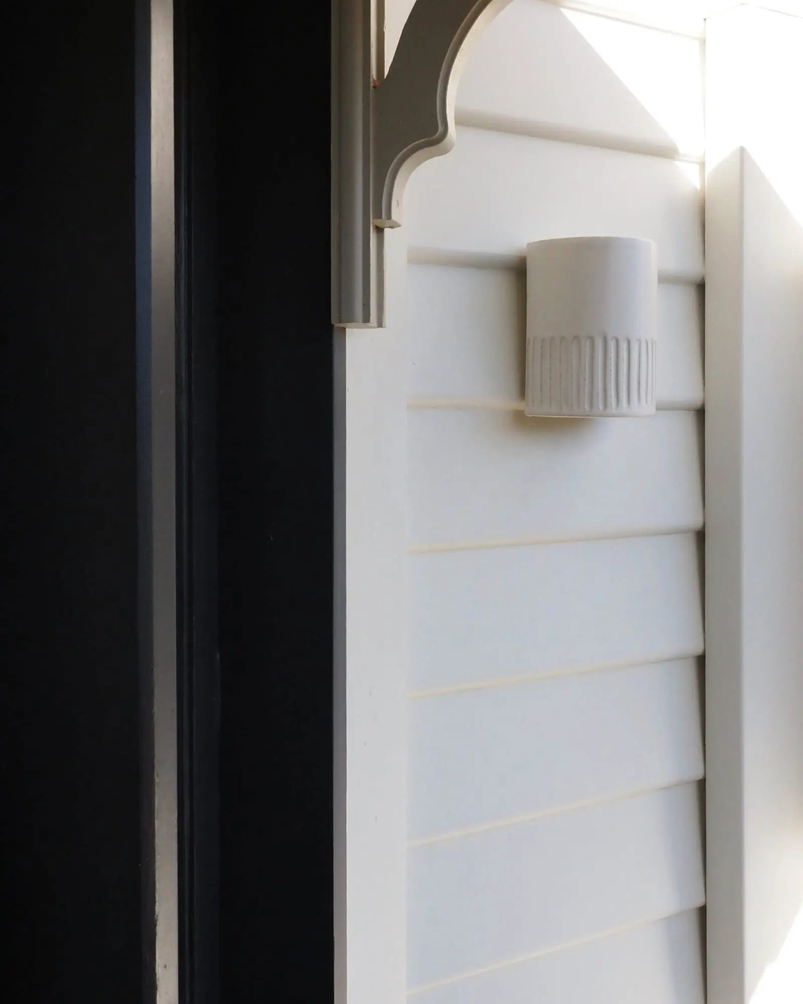 Day outdoor handmade ceramic wall light on exterior cladded wall