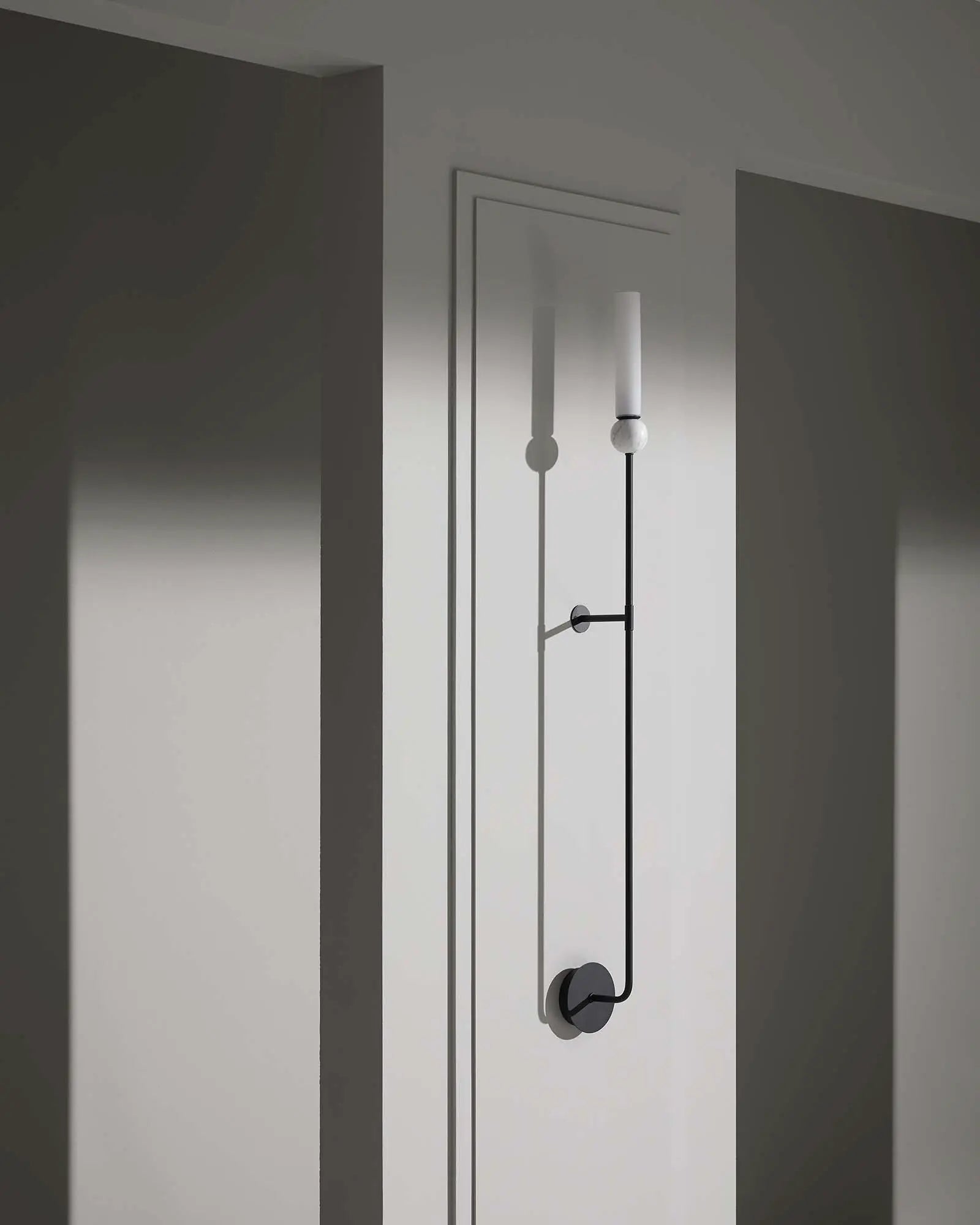 Delie Long wall light with marble sphere and cylindrical opal shade in hallway