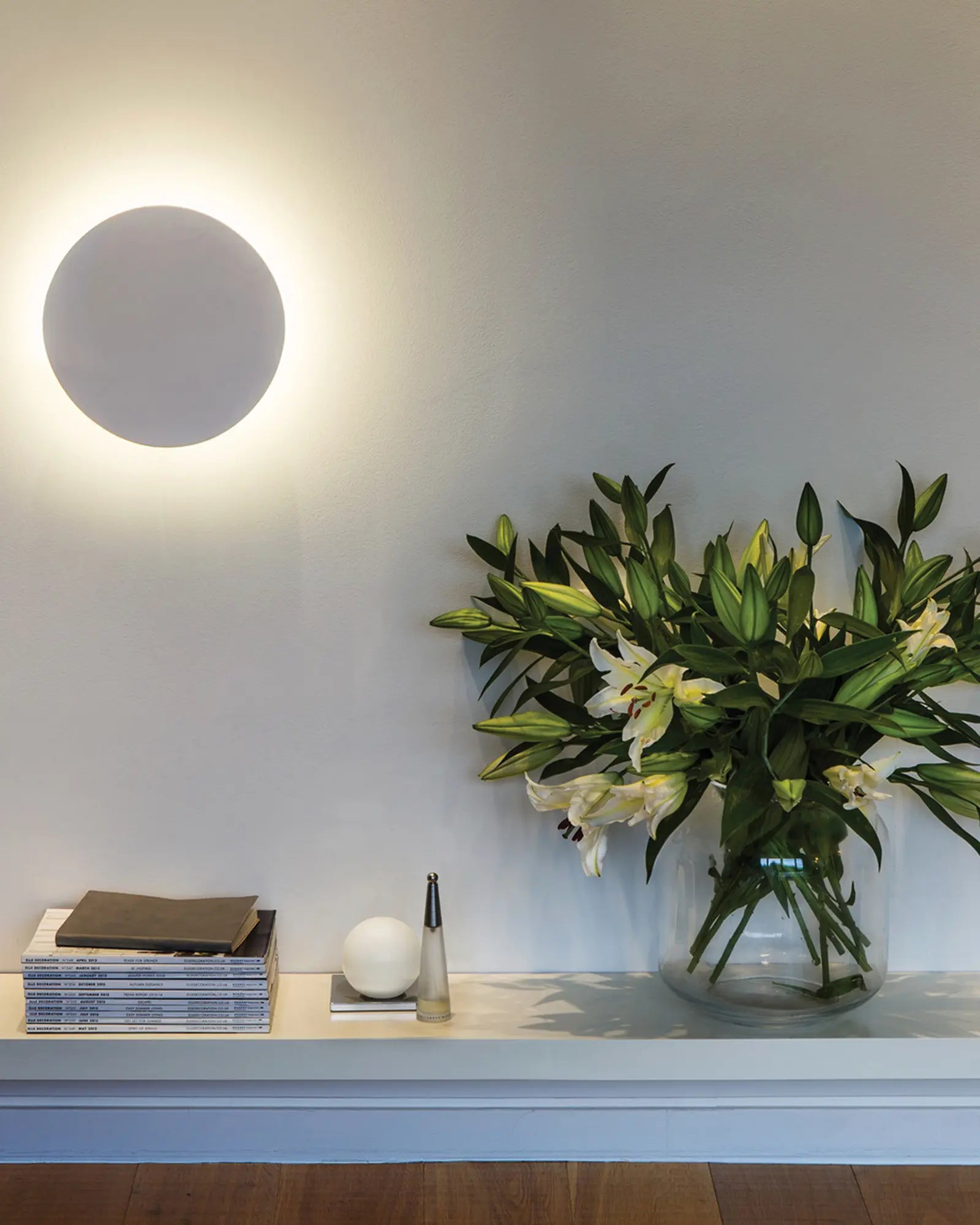 Eclipse round minimal plaster wall light above a shelf