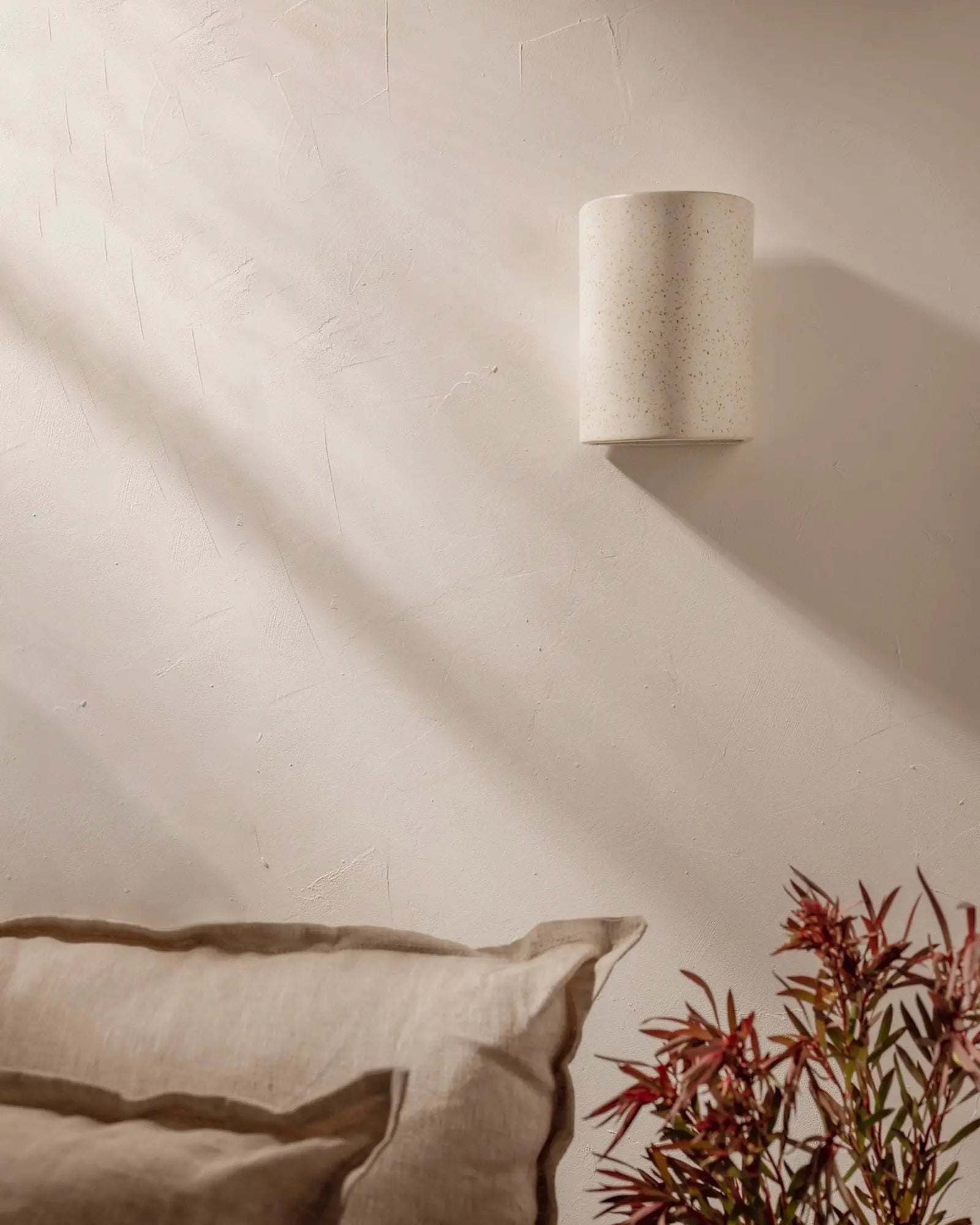 Freckles handmade ceramic wall light above a sofa