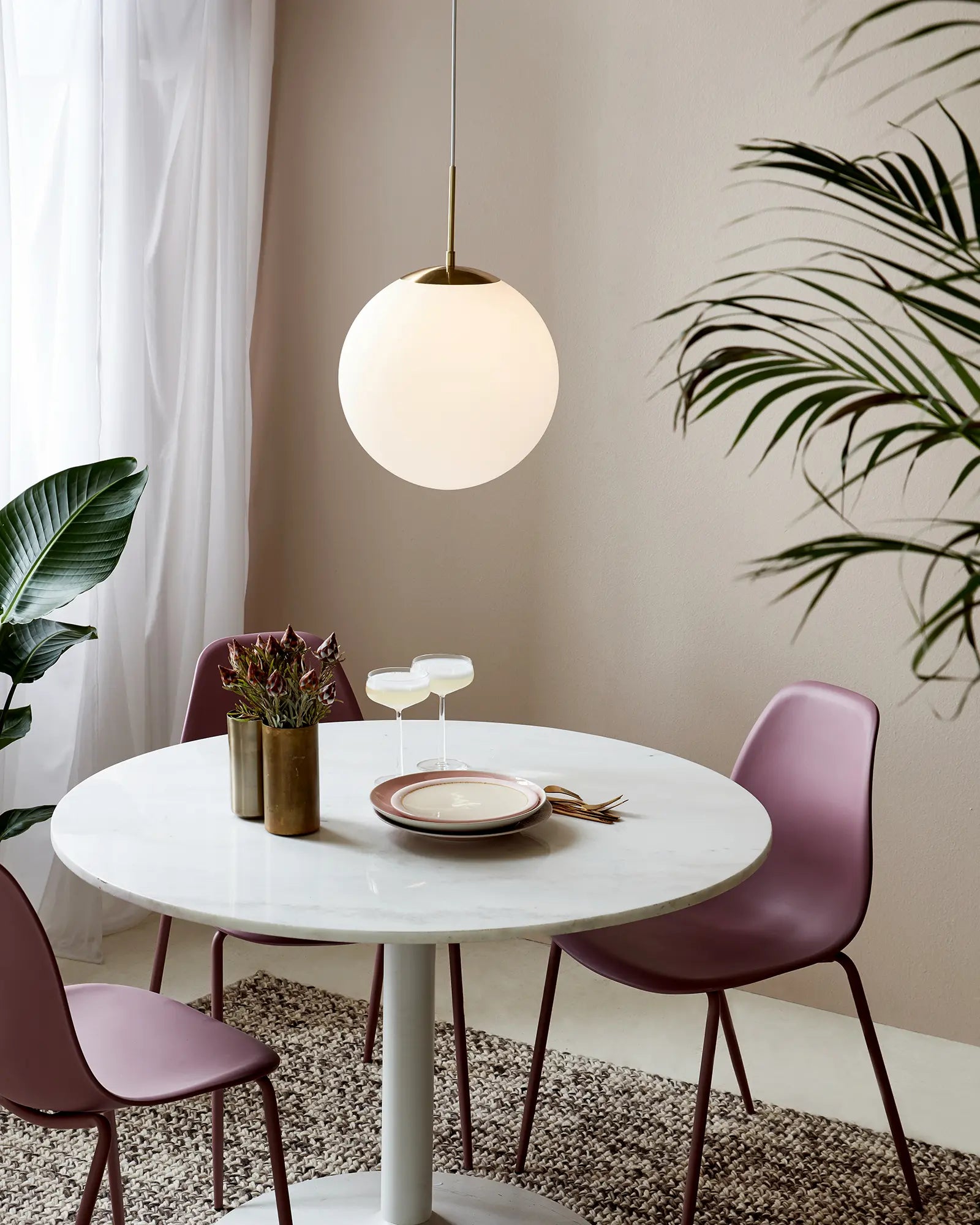Grant orb pendant light in opal and brass large above dining table