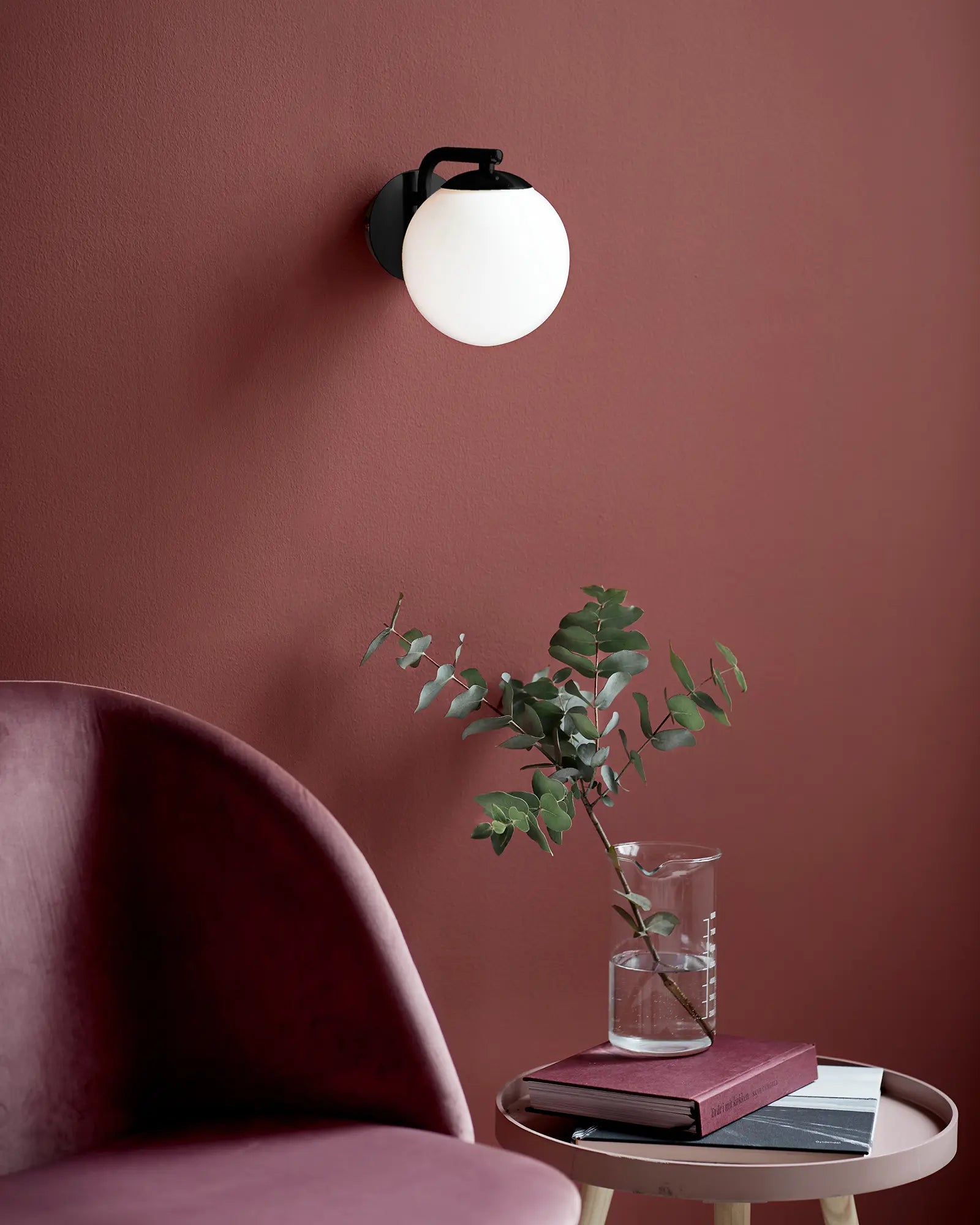 Grant Scandinavian glass orb and black wall light above a coffee table