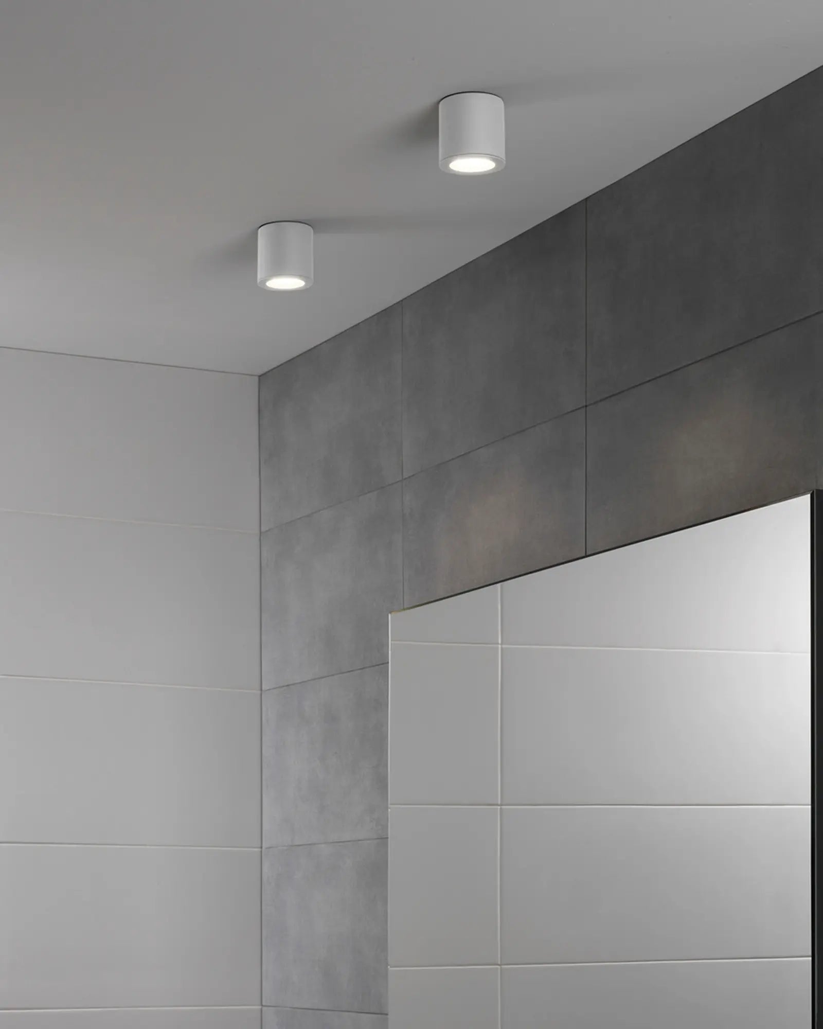 Kos II minimal cylinder metal downlight above a mirror in a bathroom