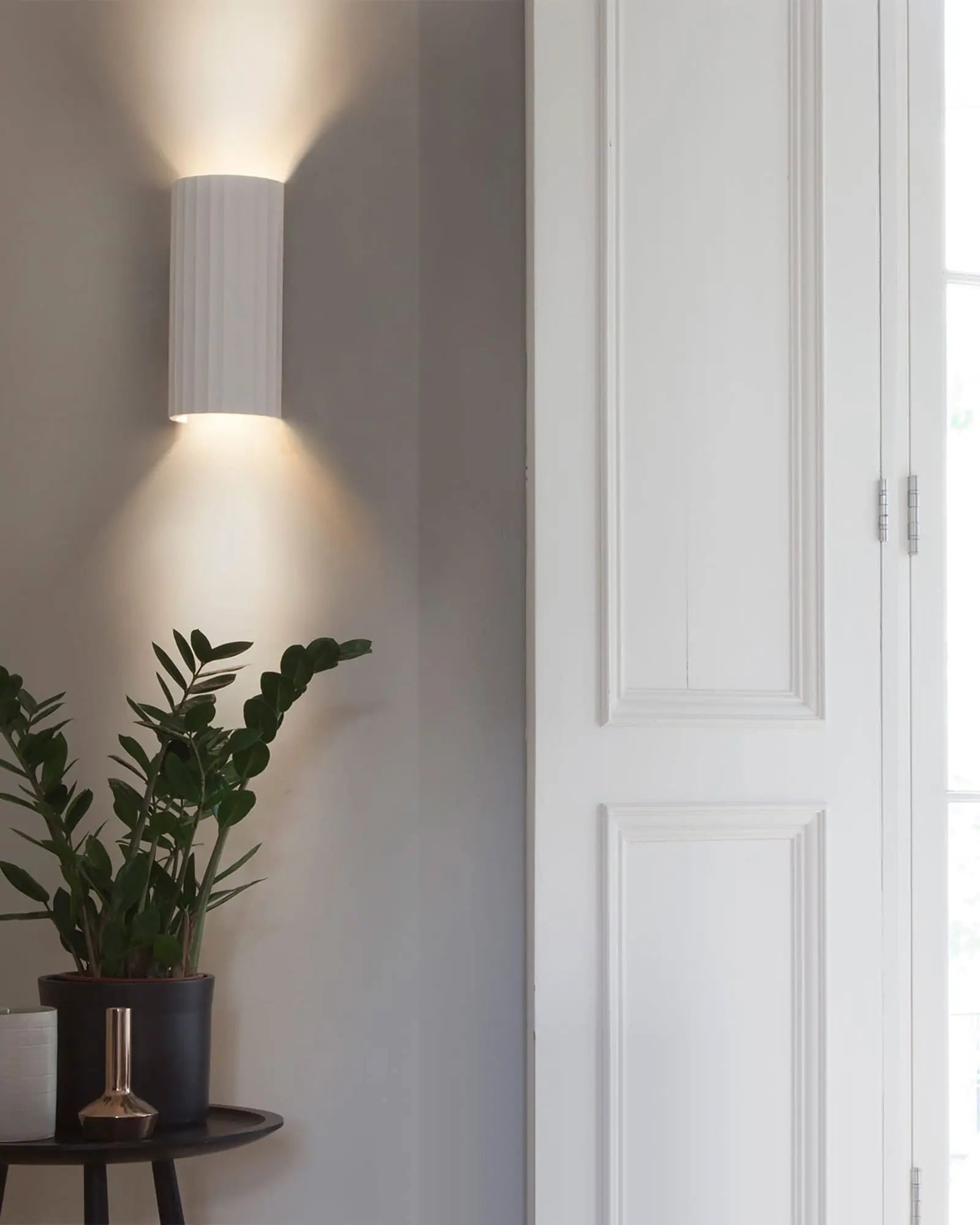 Kymi contemporary architectural wall light above a coffe table