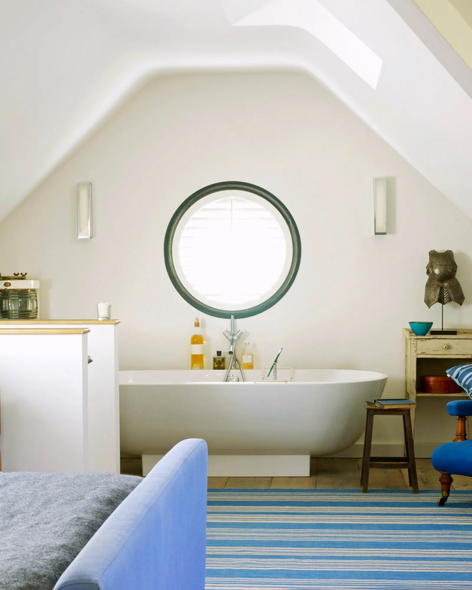 Mashiko metal and glass contemporary bathroom wall light above a bath tub