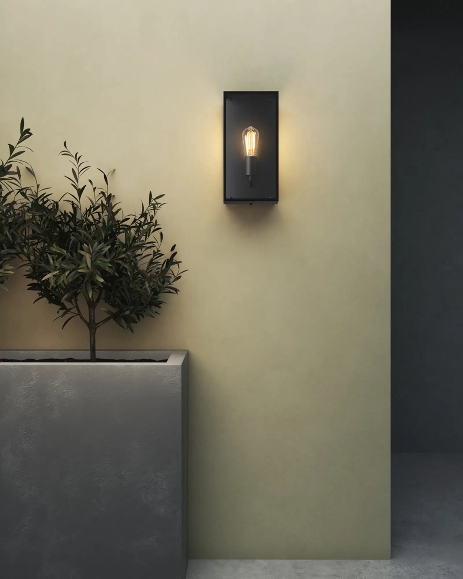 Messina modern outdoor metal and glass lantern wall light above a vase
