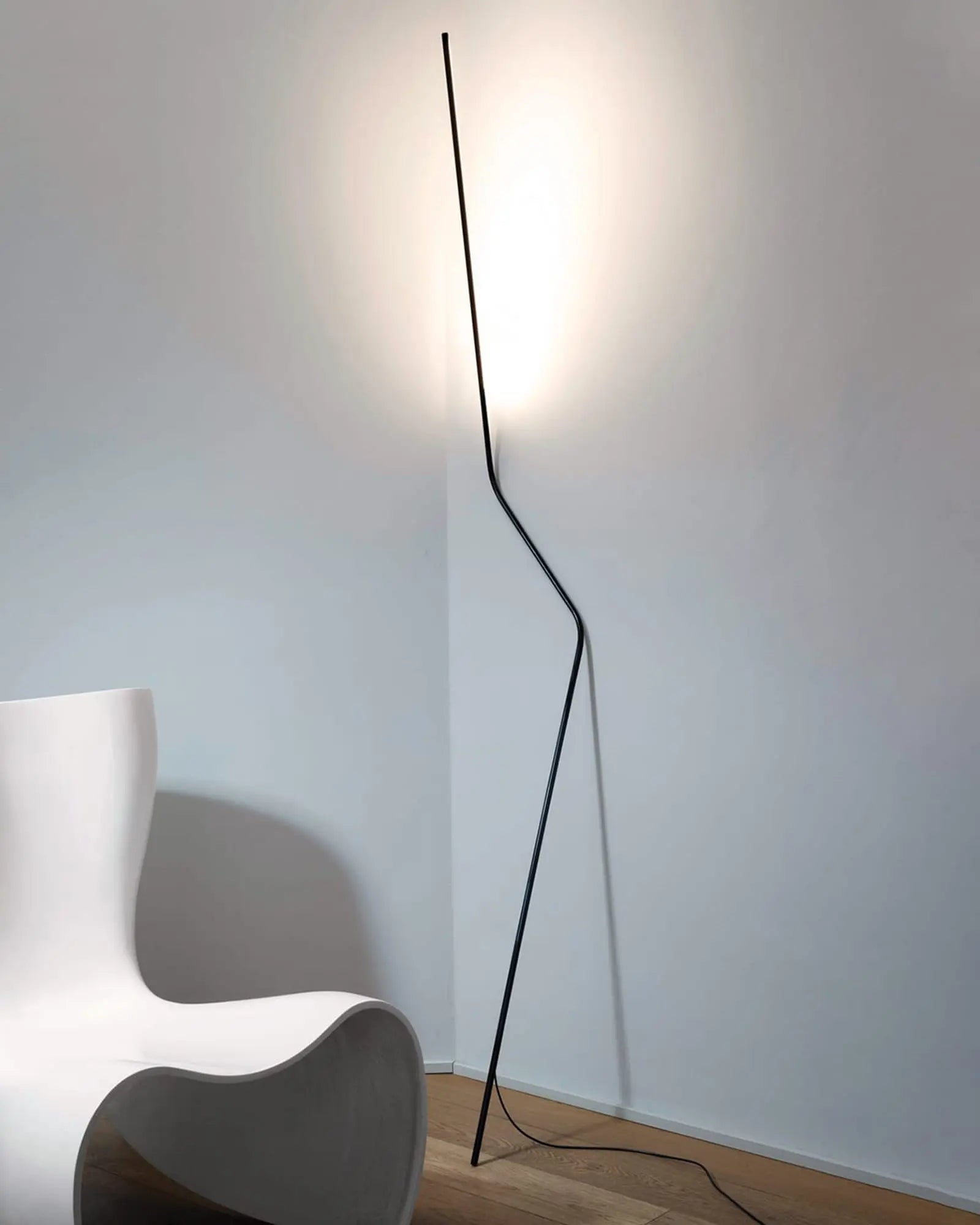 Neo modern LED floor lamp on the wall near a chair