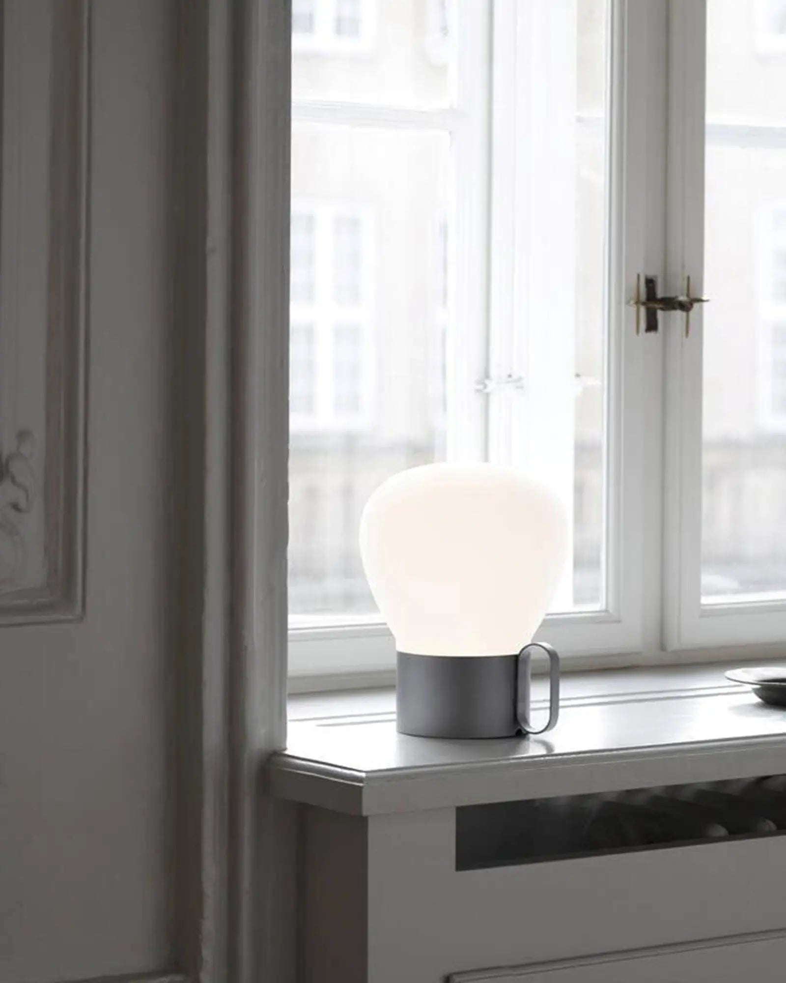 Nuru modern rechargeable Scandinavian table lamp grey on window frame