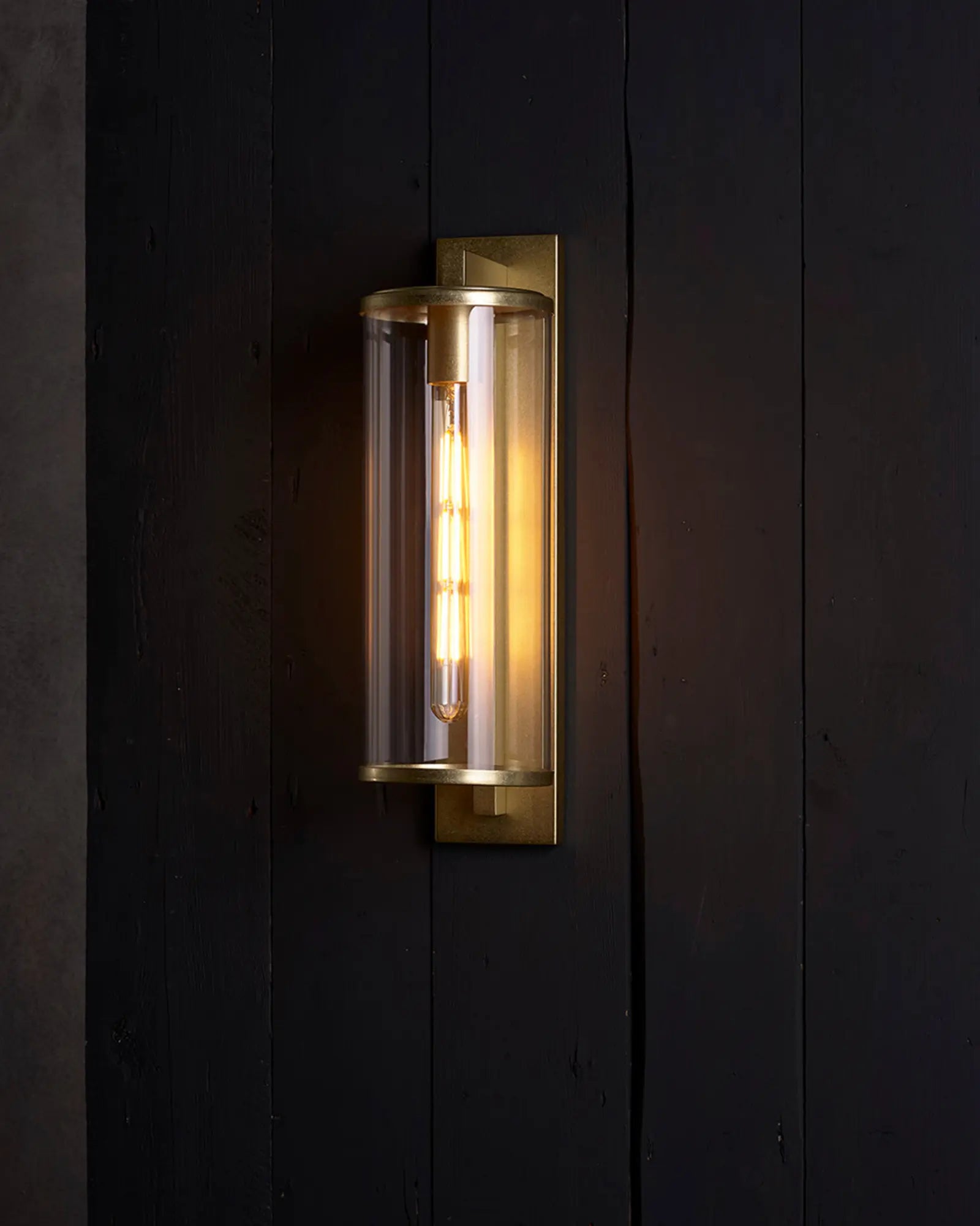 Pimlico Outdoor lantern style metal and glass wall light on cladded wall