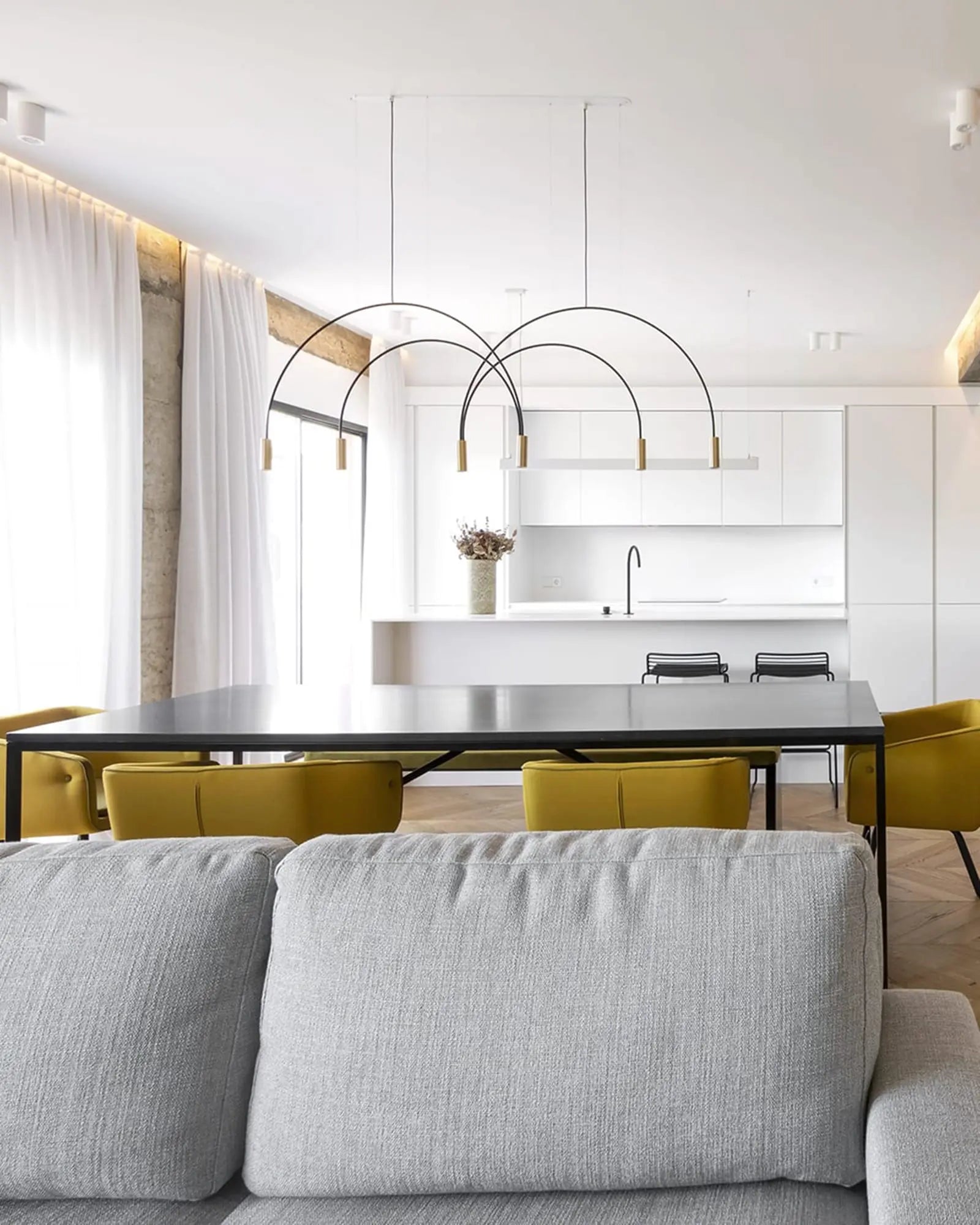 Volta Linear pendant ligh by Estiluz Lightingt in a living area above table