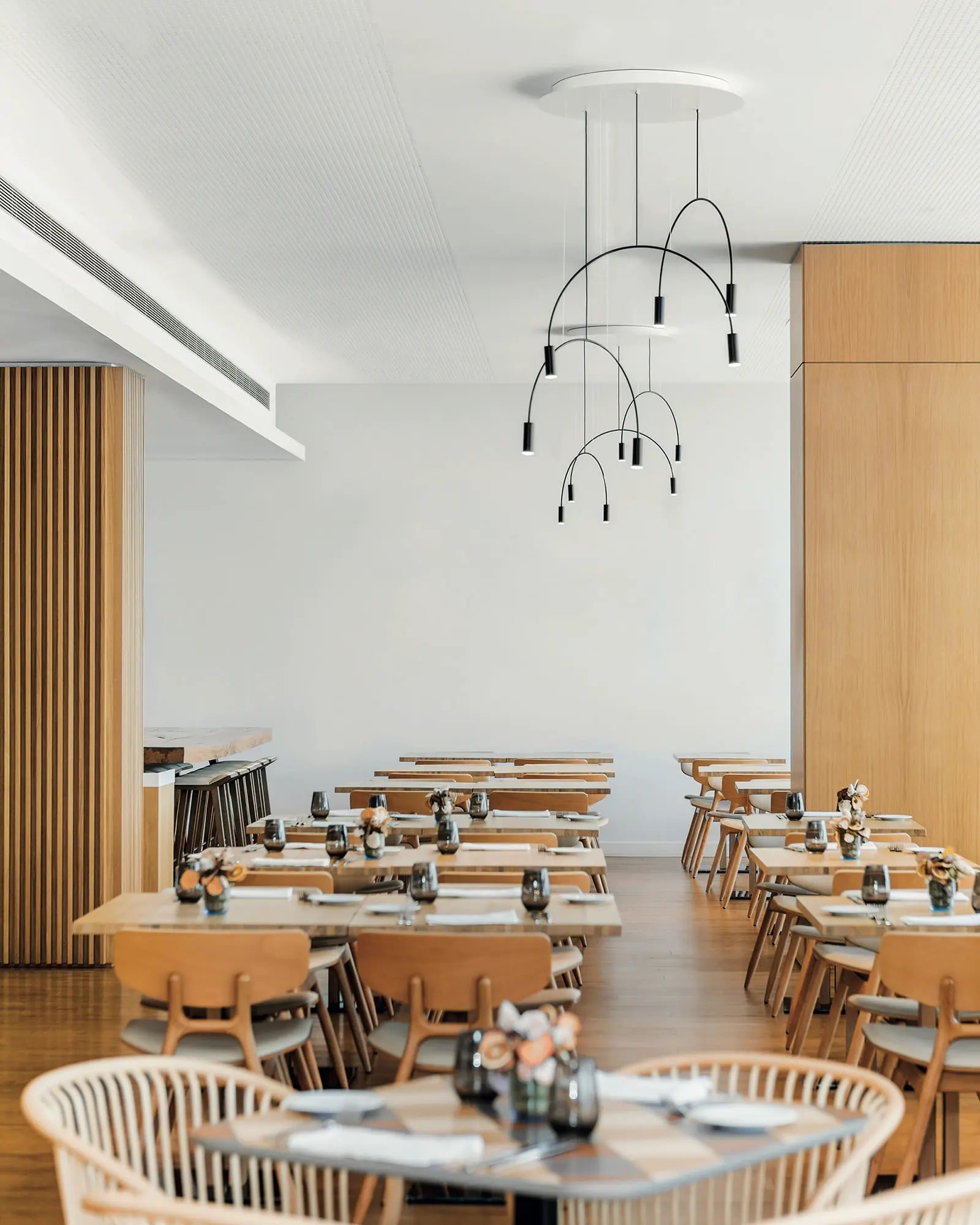 Volta Linear pendant light by Estiluz Lighting cluster in a restaurant