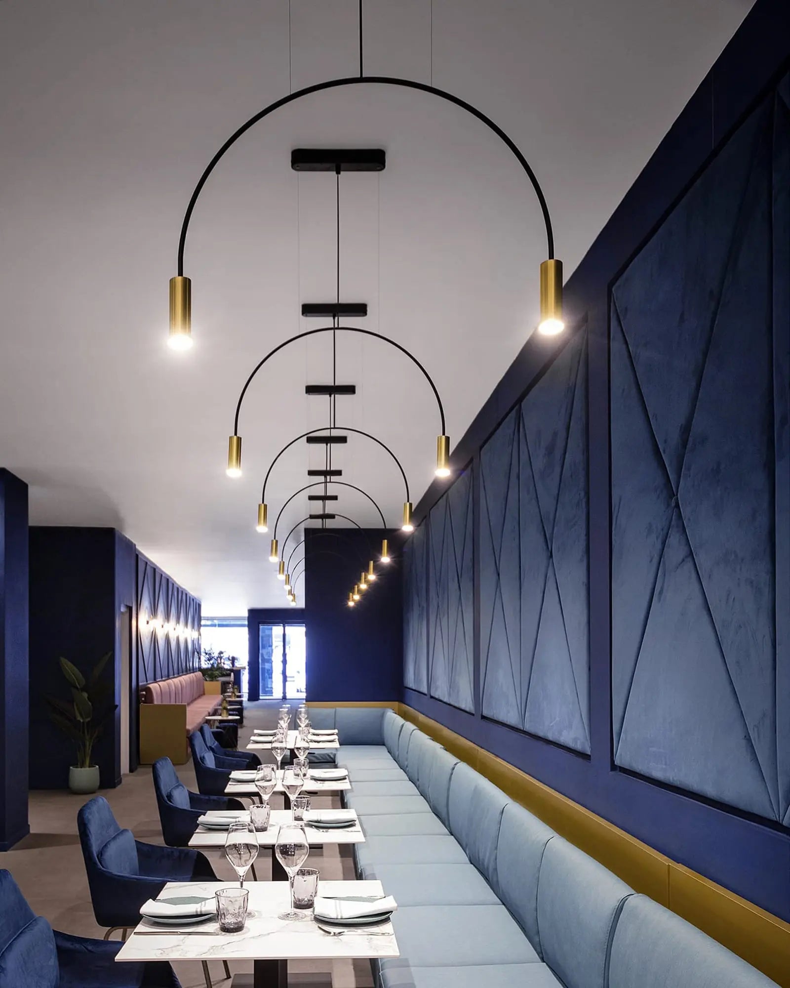 Volta Linear pendant light by Estiluz Lighting cluster in a restaurant above tables