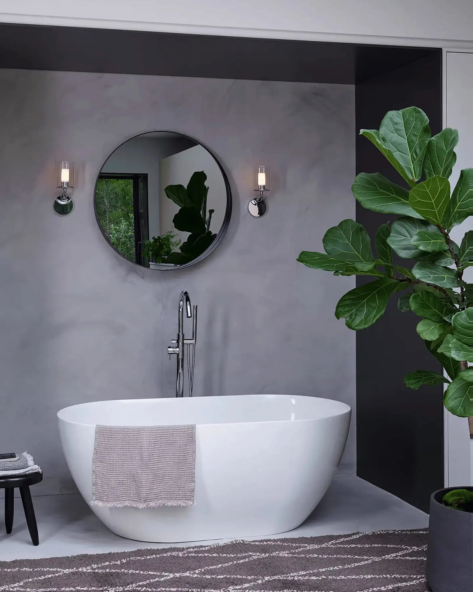 Elena wall light above a bath tub in a bathroom on the mirror sides