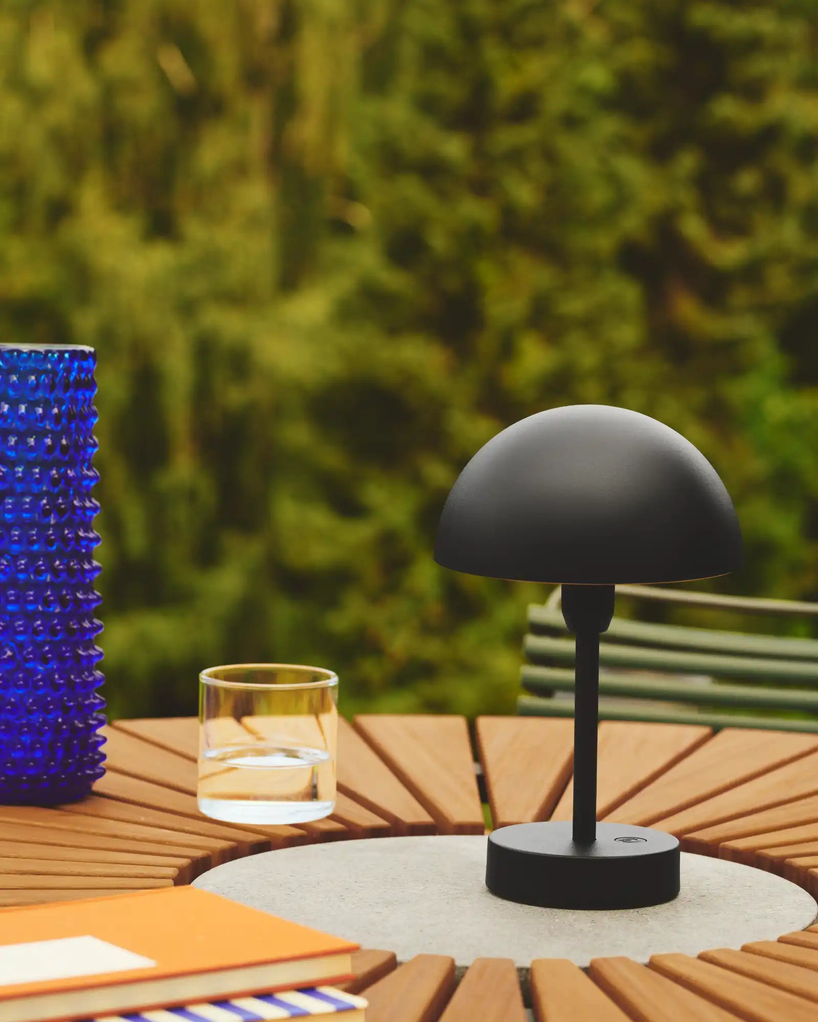 Ellen To-Go Table Lamp Black by Nordlux Lighting featured in an outdoor lounge area | Nook Collections