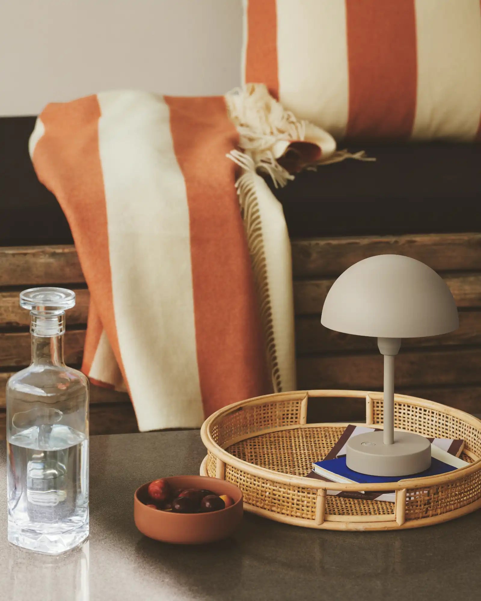 Ellen To-Go Table Lamp by Nordlux Lighting featured in an outdoor lounge area | Nook Collections