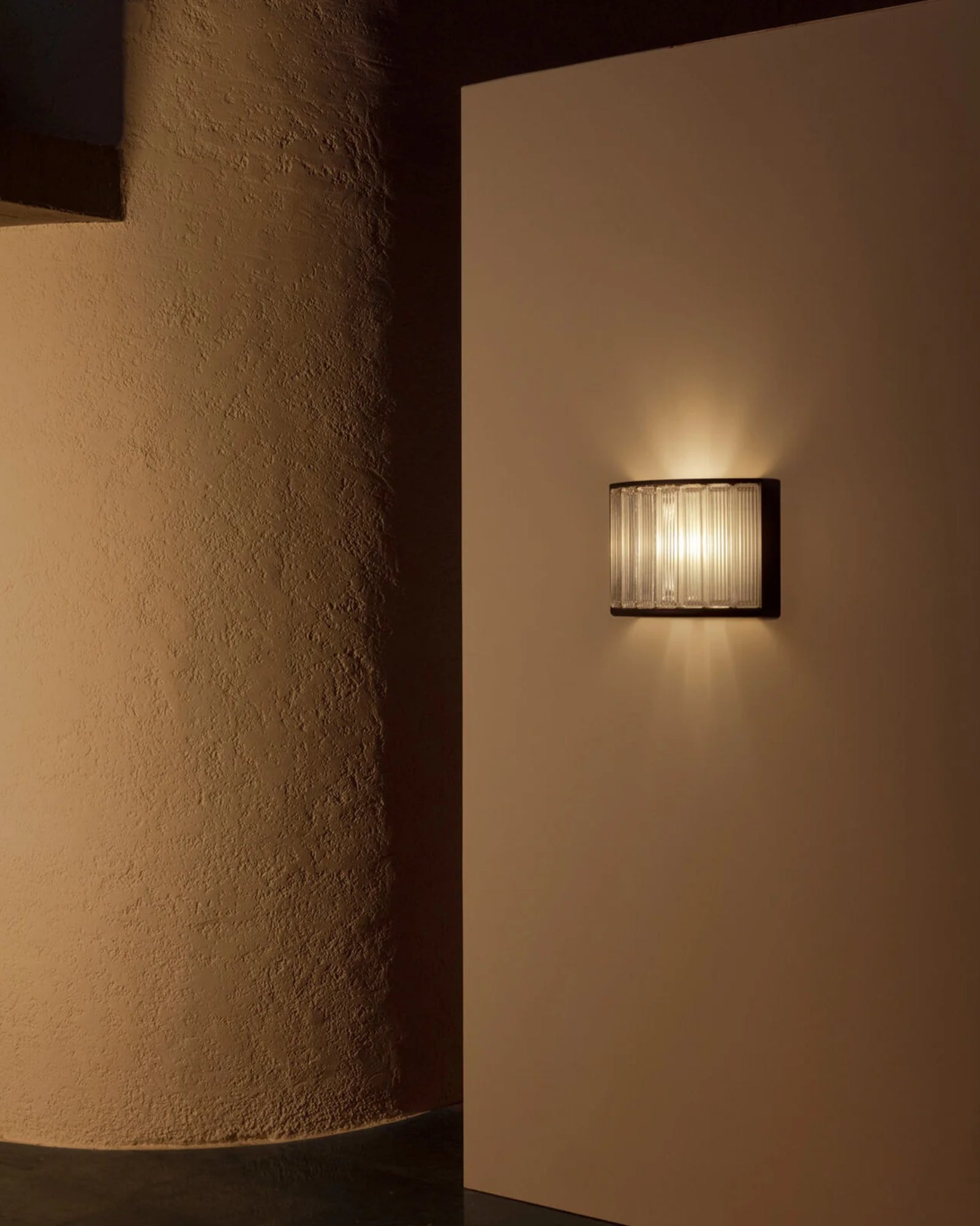 Estadio Wall Light by Santa & Cole featured in an outdoor hallway | Nook Collections