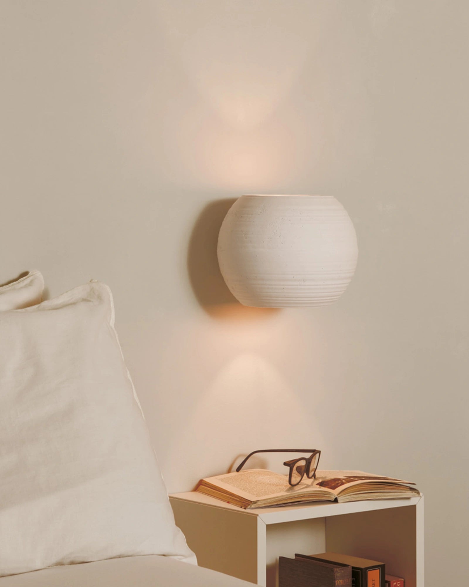 Newton Ceramic orb wall light featured as a bedside light