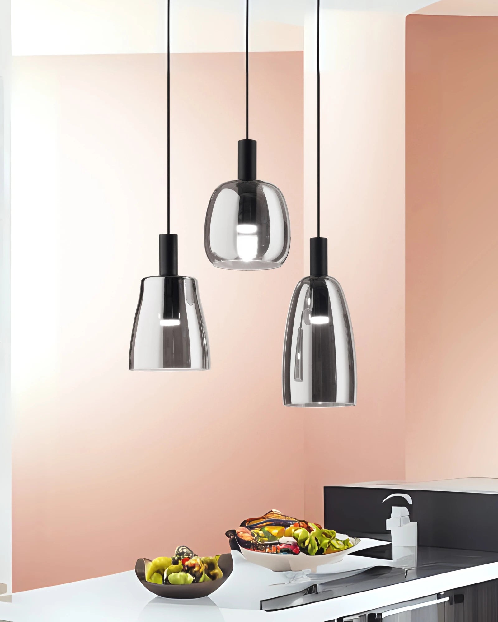 Modern pendant lights hanging above a dining table with food.