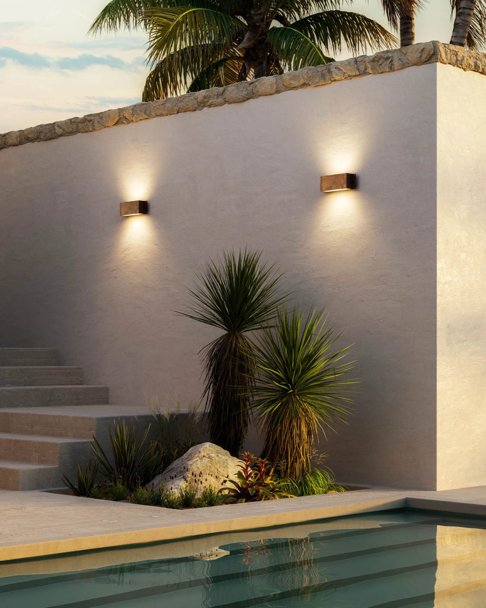 Outdoor setting with decori wall lights by Il Fanale, plants, and a pool.