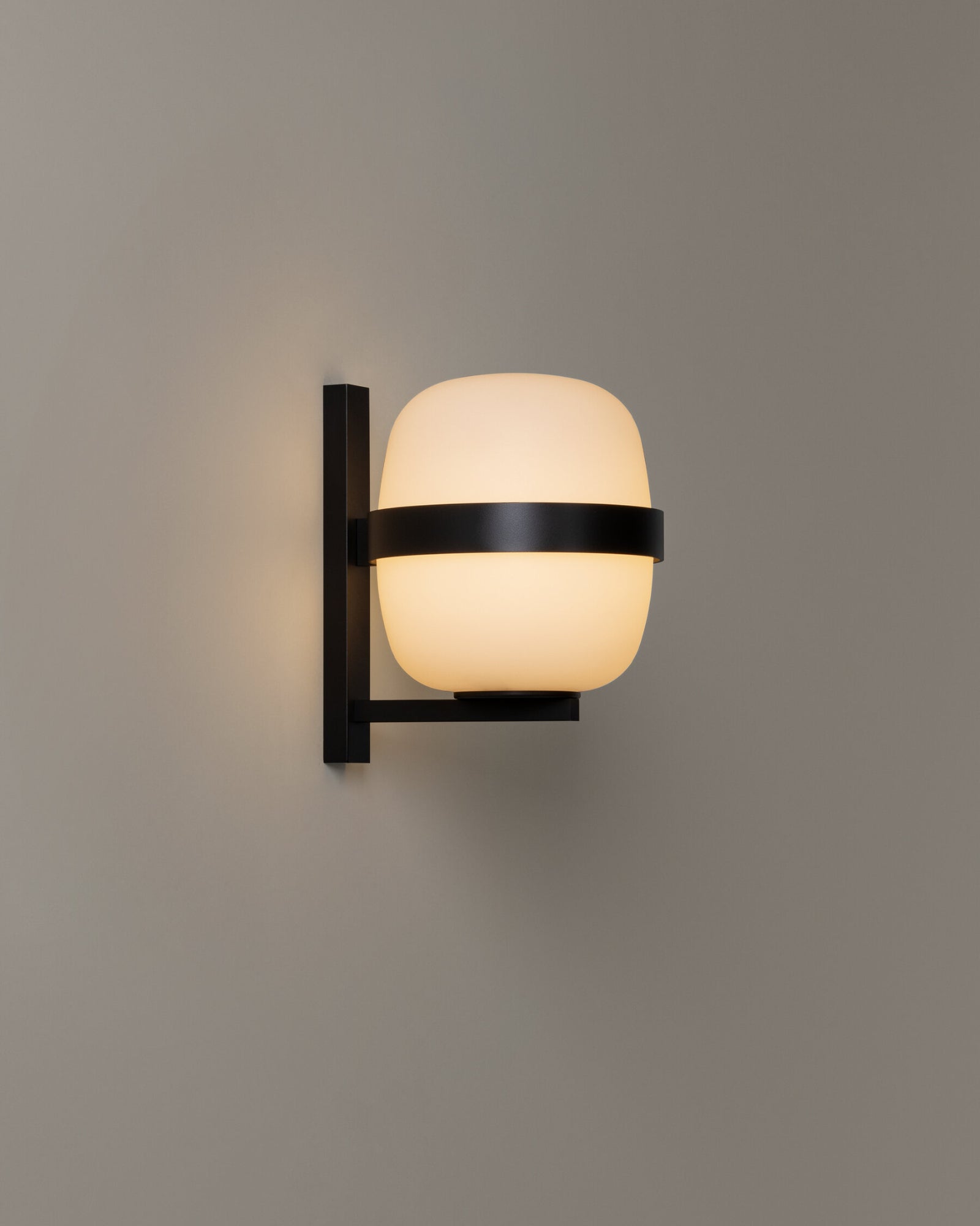 Black metal outdoor wall light with a spherical white glass shade | Nook Collections