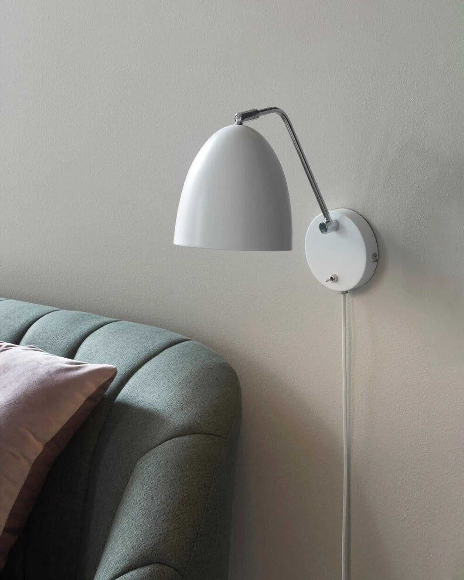 Alexander Wall Light Scandinavian minimalistic dome in white on the side of a sofa bed