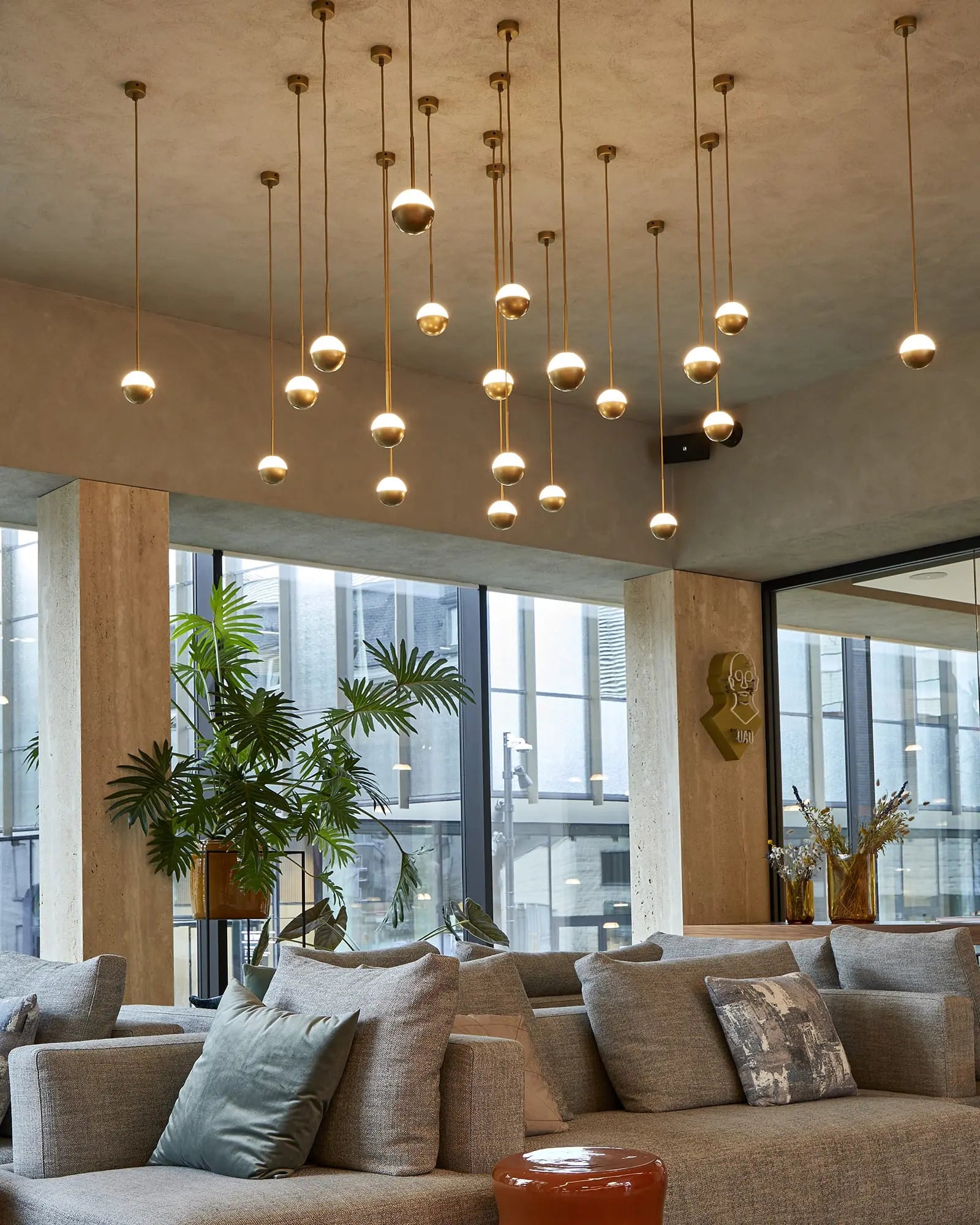 Alfi Single orb opal and metal pendant light in brass with shade cluster in living area over a sofa