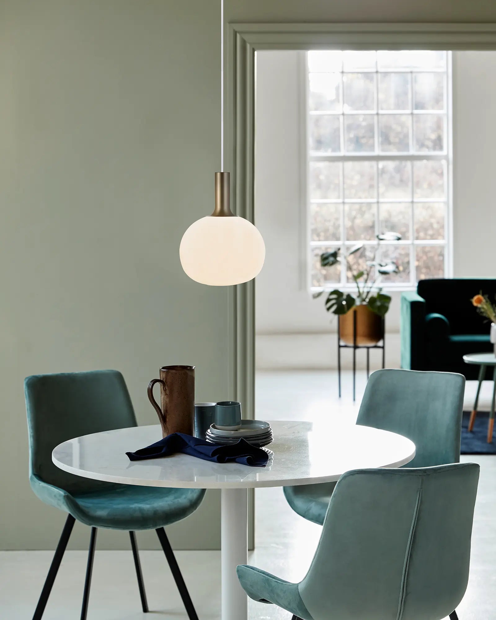 Alton Scandinavian Pendant light in blown glass opal and brass above a round table
