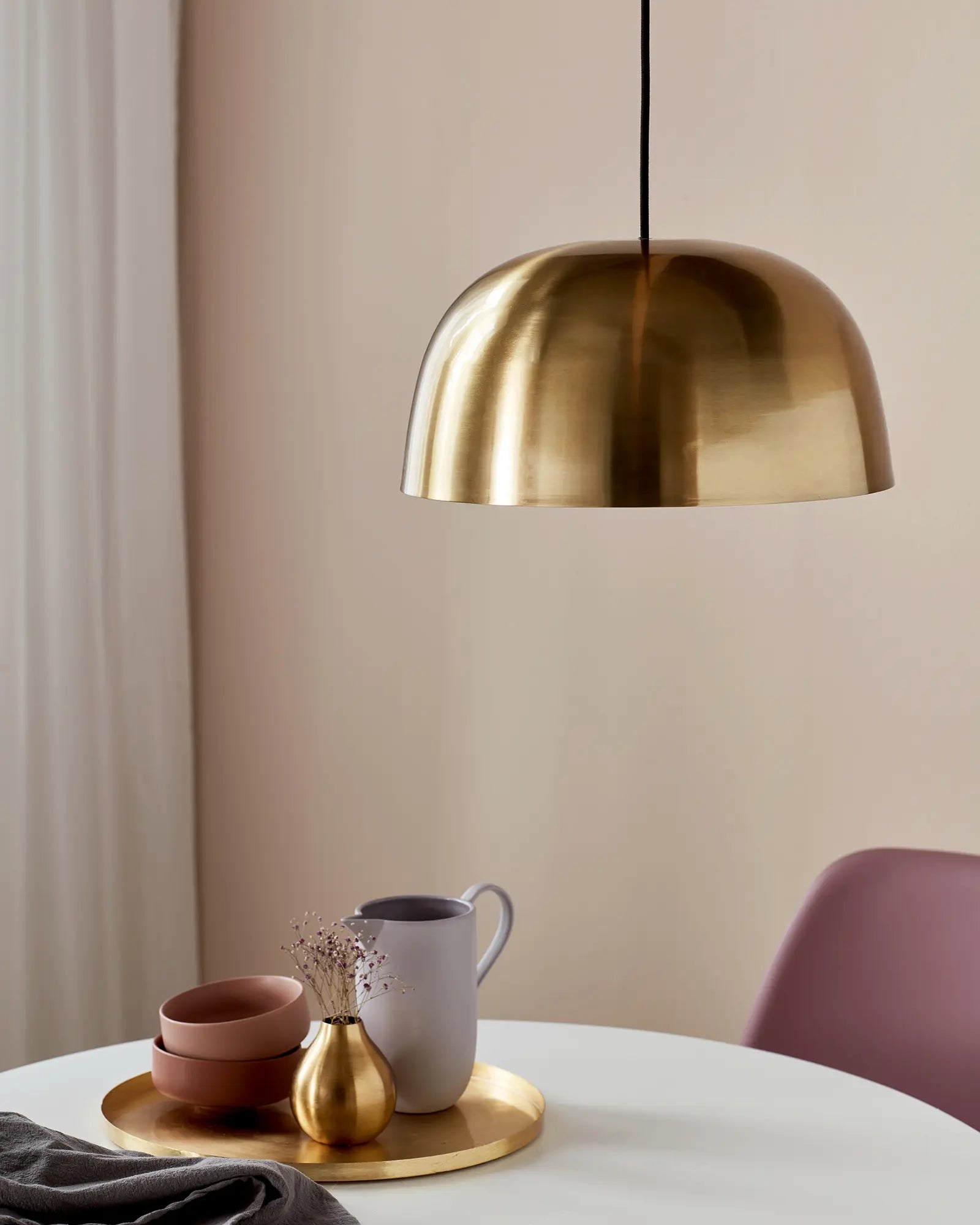Cera large brass dome pendant light above a dining table