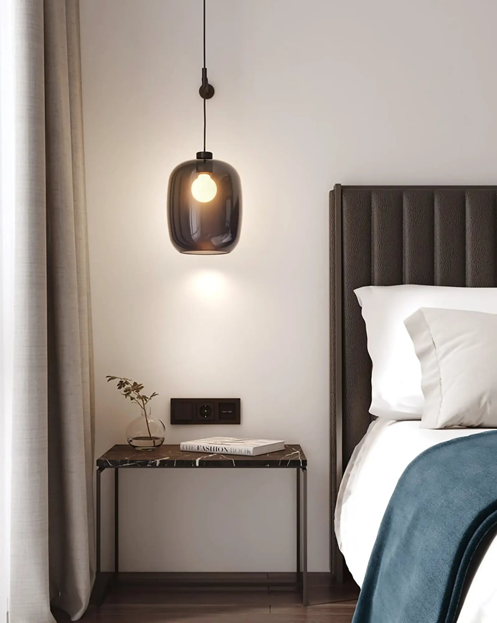 Curve contemporary pendant light with wall mount and smoke blown glass shade on a bed side