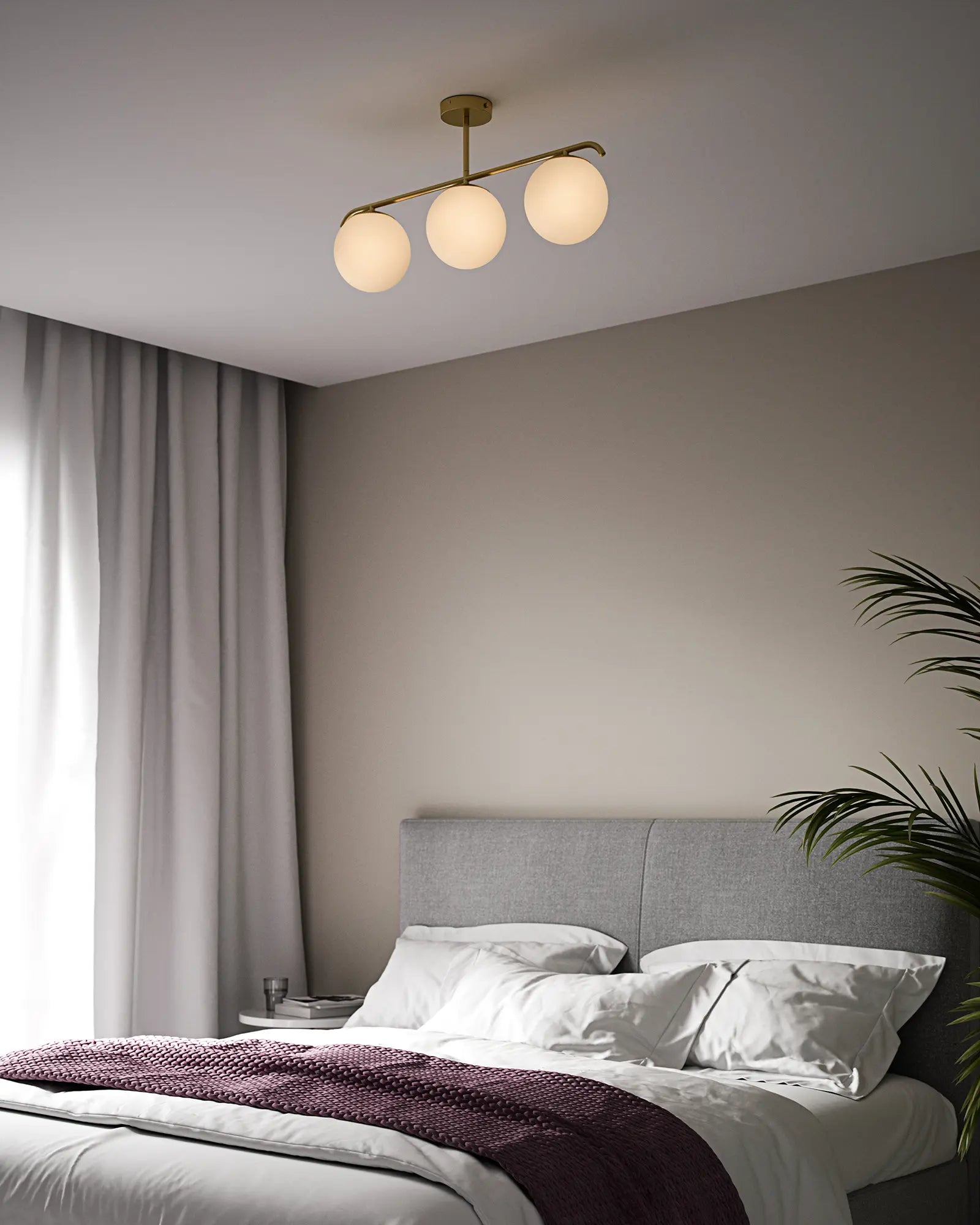 Grant orb pendant light in opal and brass 3 lights above a bed