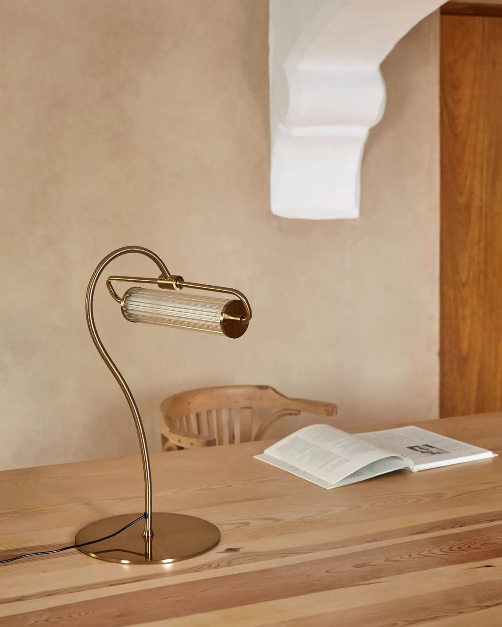 Ison contemporary pendant light with ribbed glass shade on a wooden desk