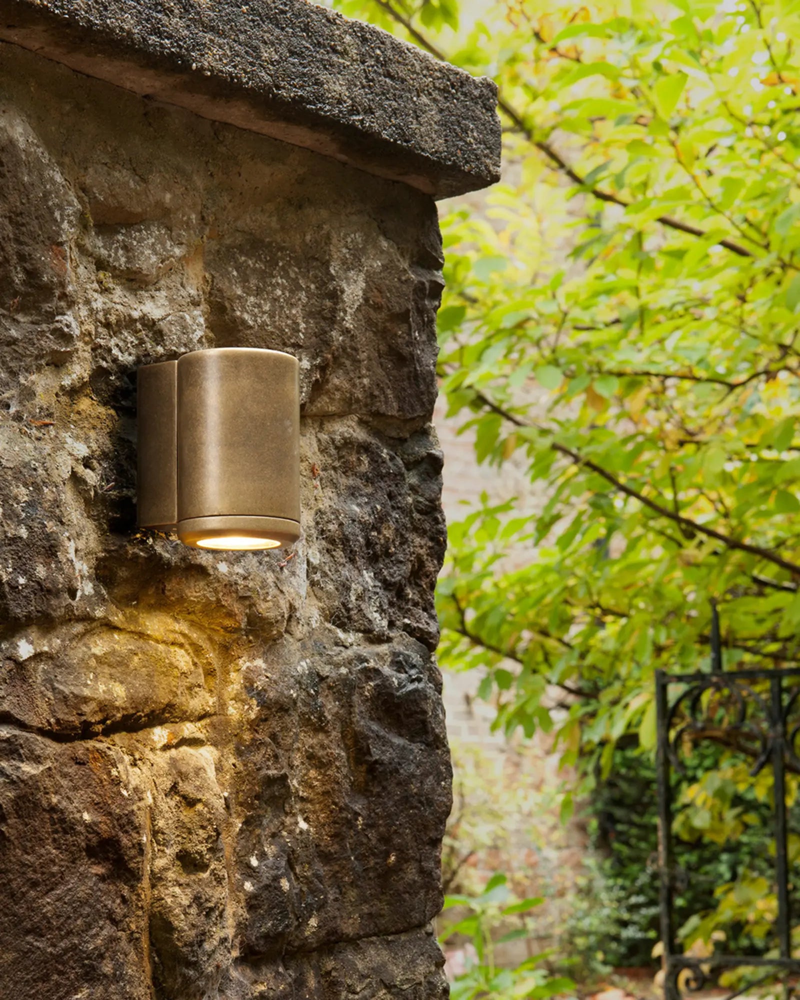 Jura coastal brass outdoor wall light on a stone wall