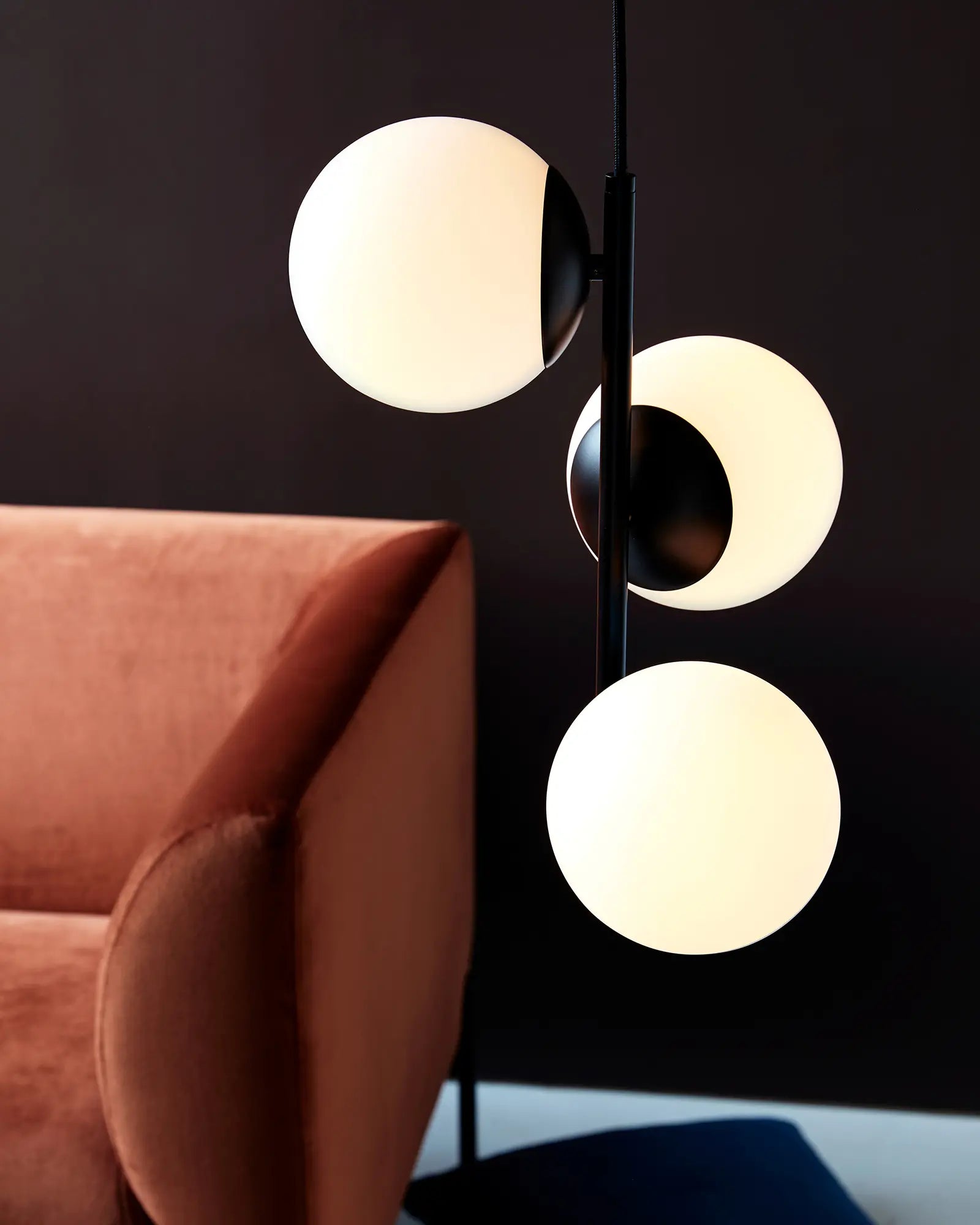 Lilly Pendant light 3 orbs scandinavian opal glass black on a side of a sofa