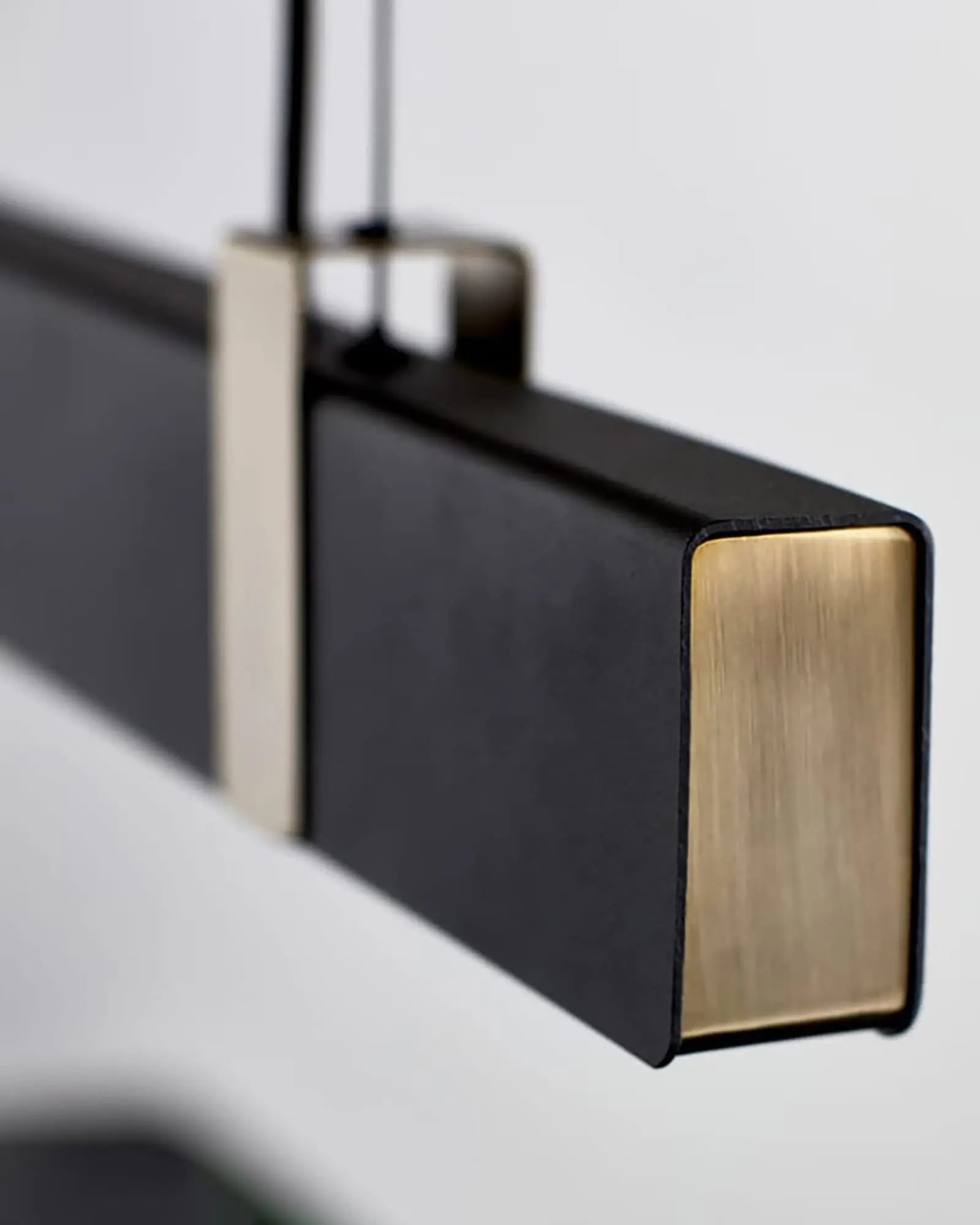 Lilt Scandinavian contemporary linear pendant light in black and brass detail