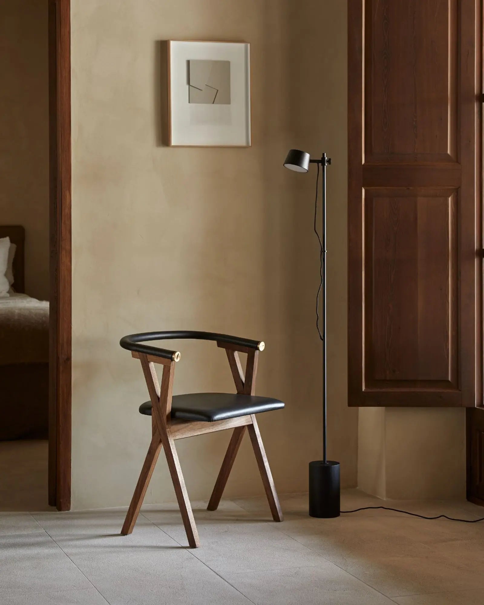 Nera Floor Lamp contemporary adjustable head all black beside a reading chair