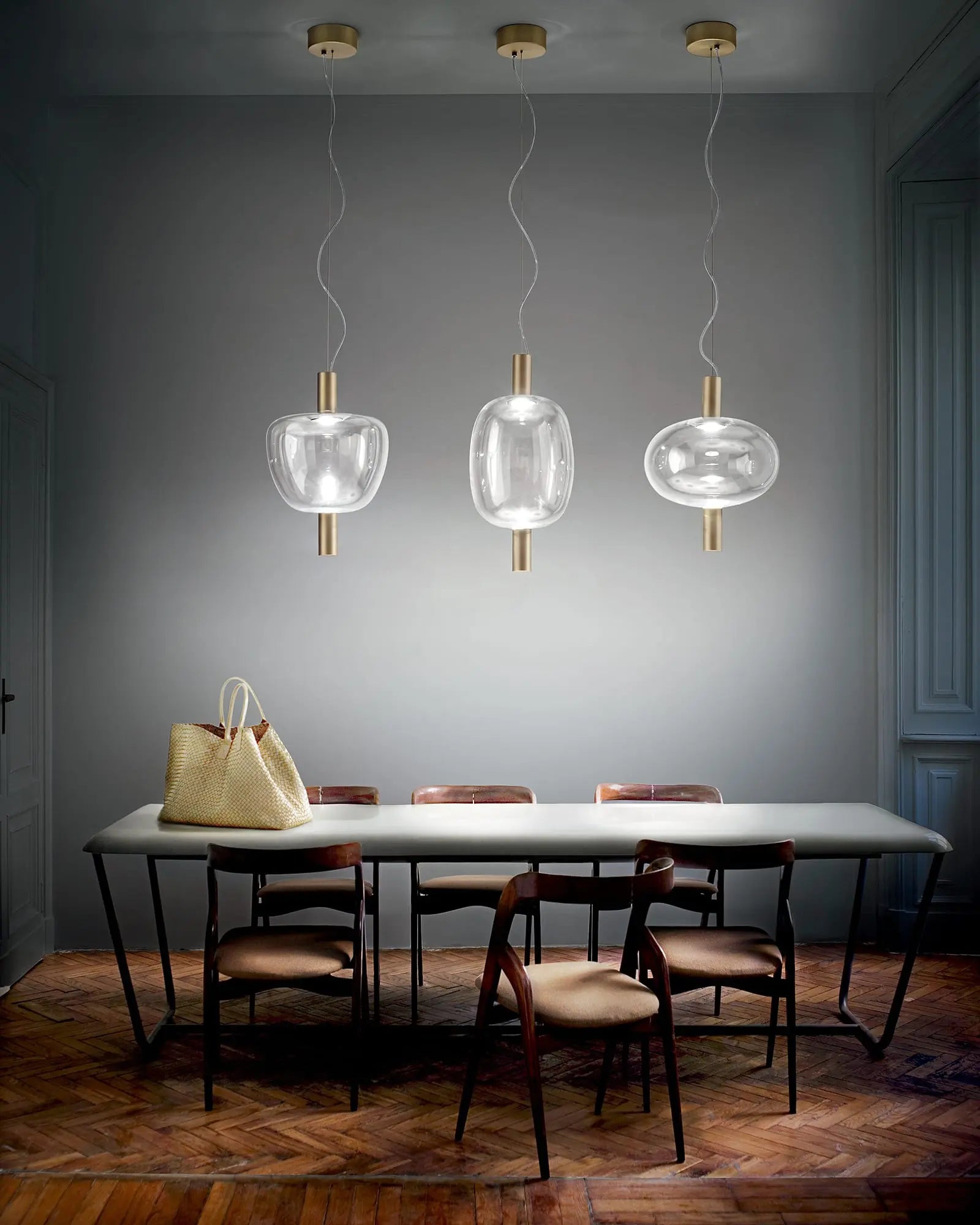 Riflesso modern blown glass and metal pendant light cluster above dining table