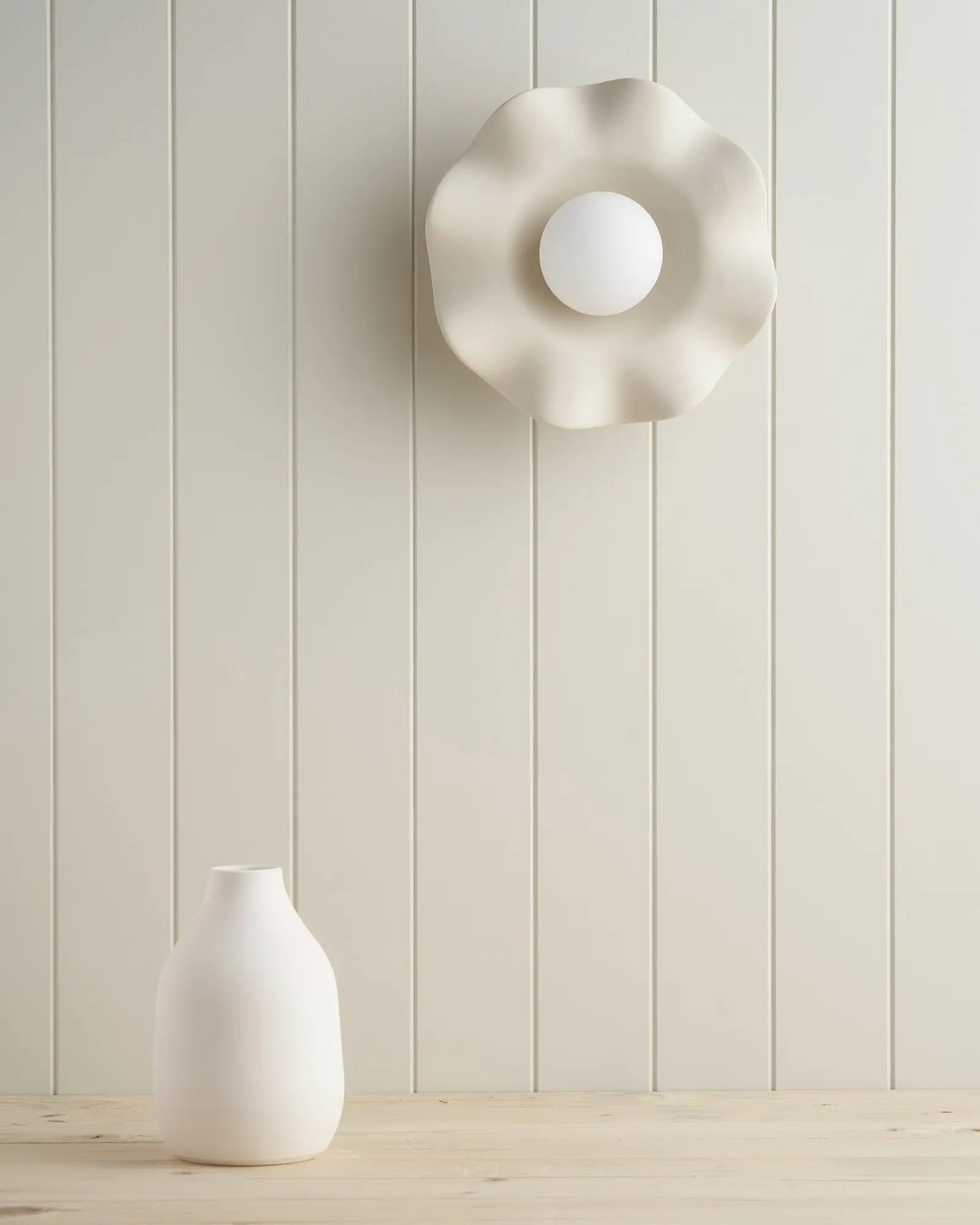 Pearl Ceramic wavy wall light over a table