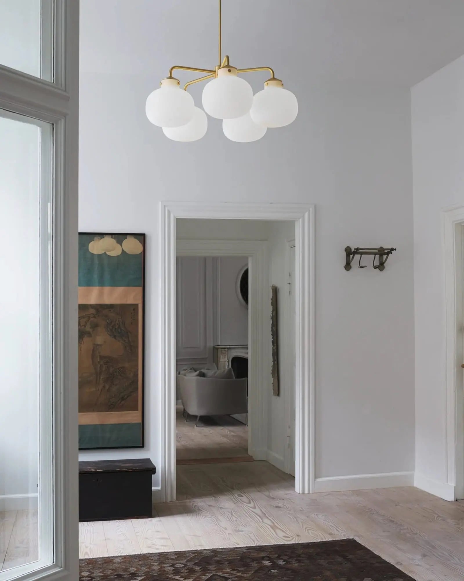 Raito 5 brass and opal glass pendant light in an entrance